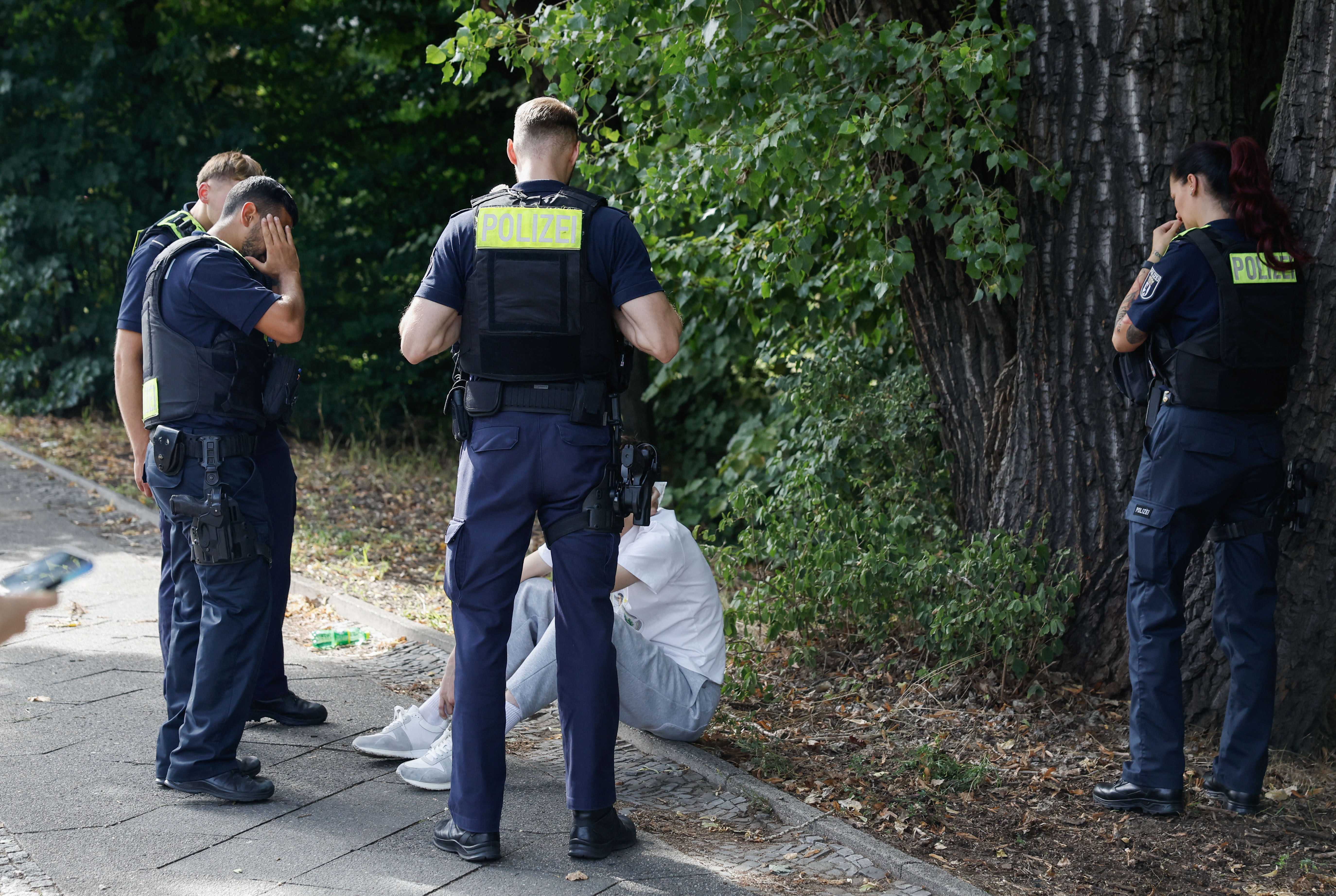 Polizisten sprechen mit einer Person am Unfallort. | Quelle: GettyImages