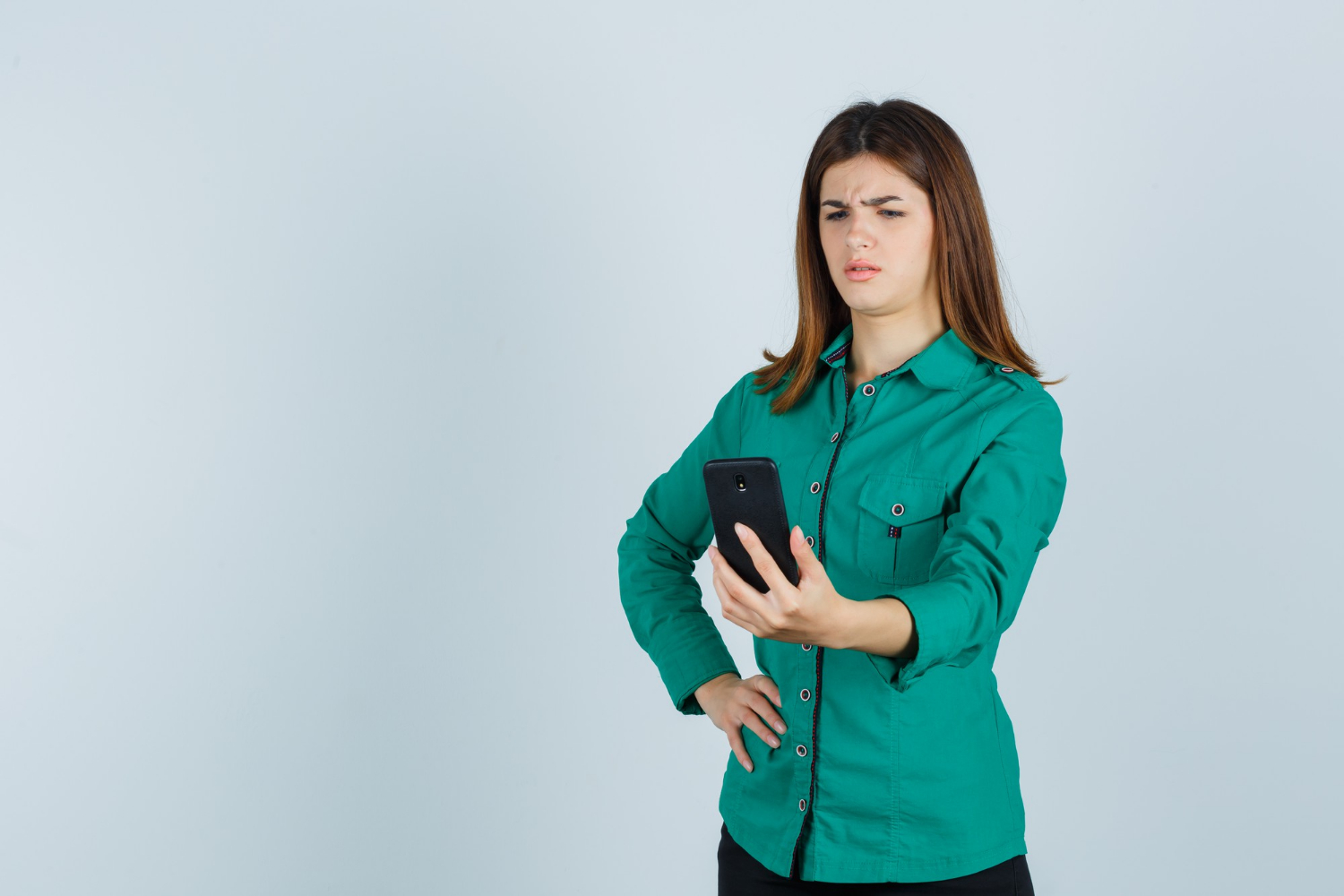 Eine fassungslose Frau starrt auf ihr Telefon | Quelle: Freepik
