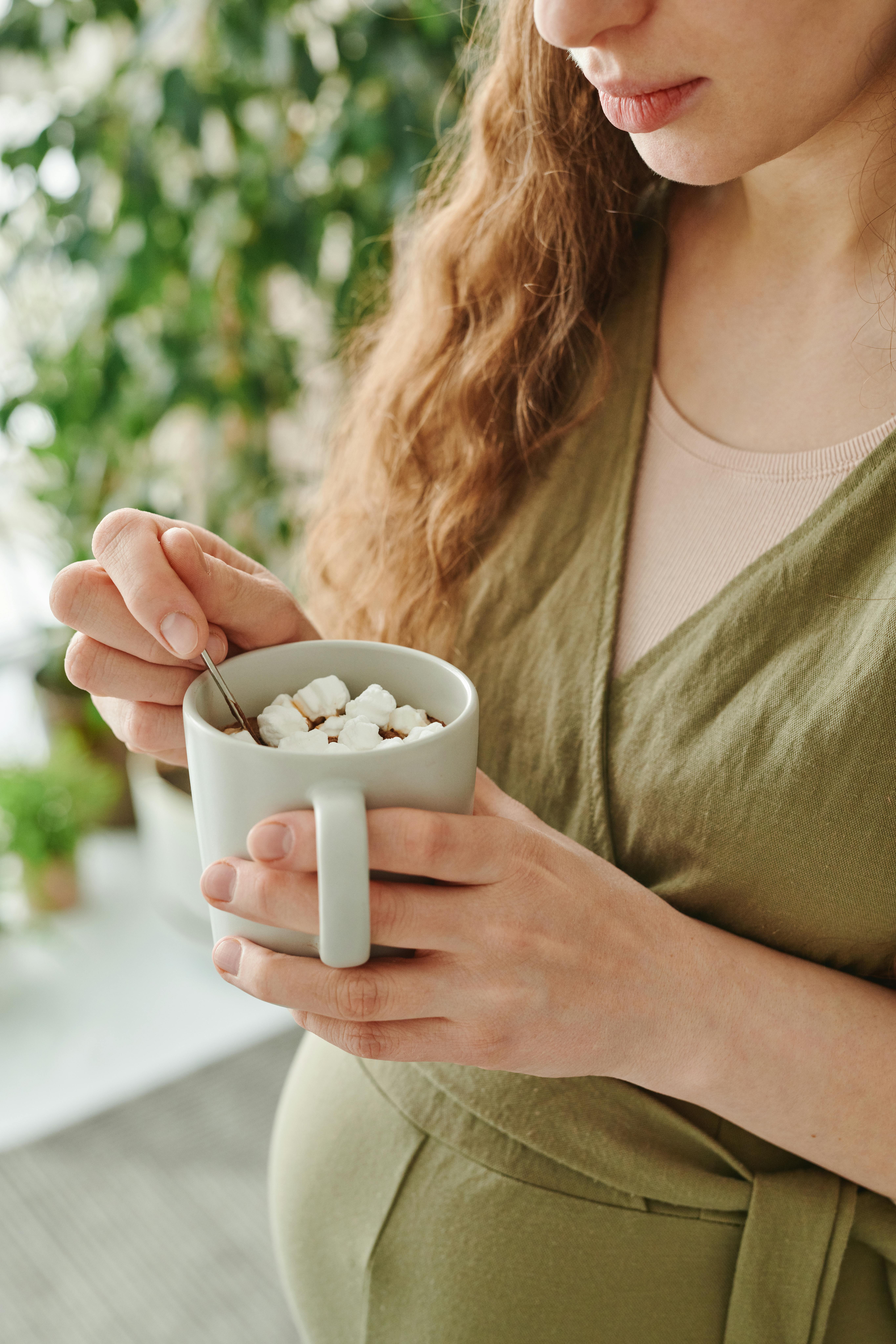 Eine Frau hält eine Tasse mit heißer Schokolade | Quelle: Pexels