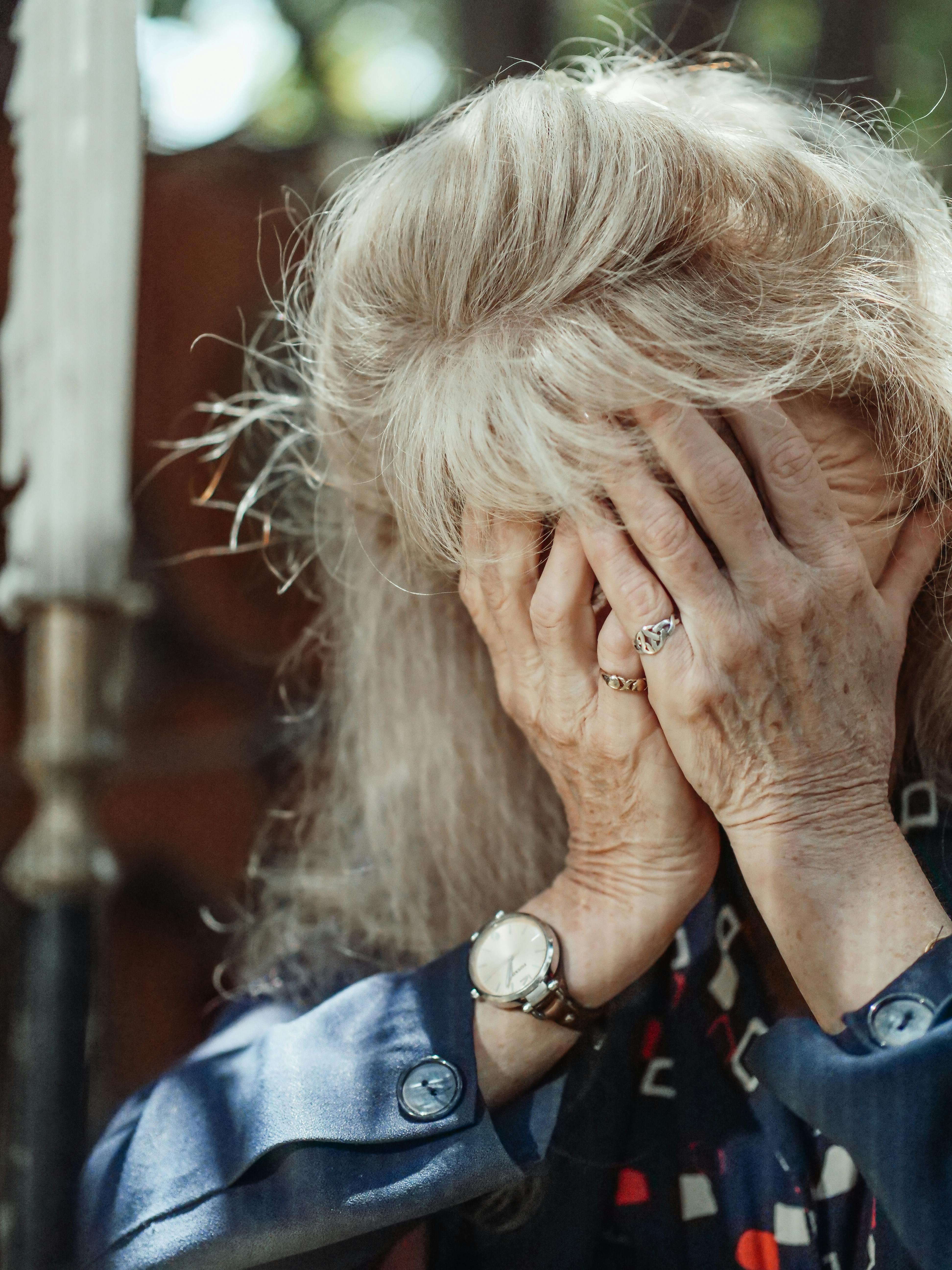 Eine alte Frau, die ihren Kopf hält | Quelle: Pexels