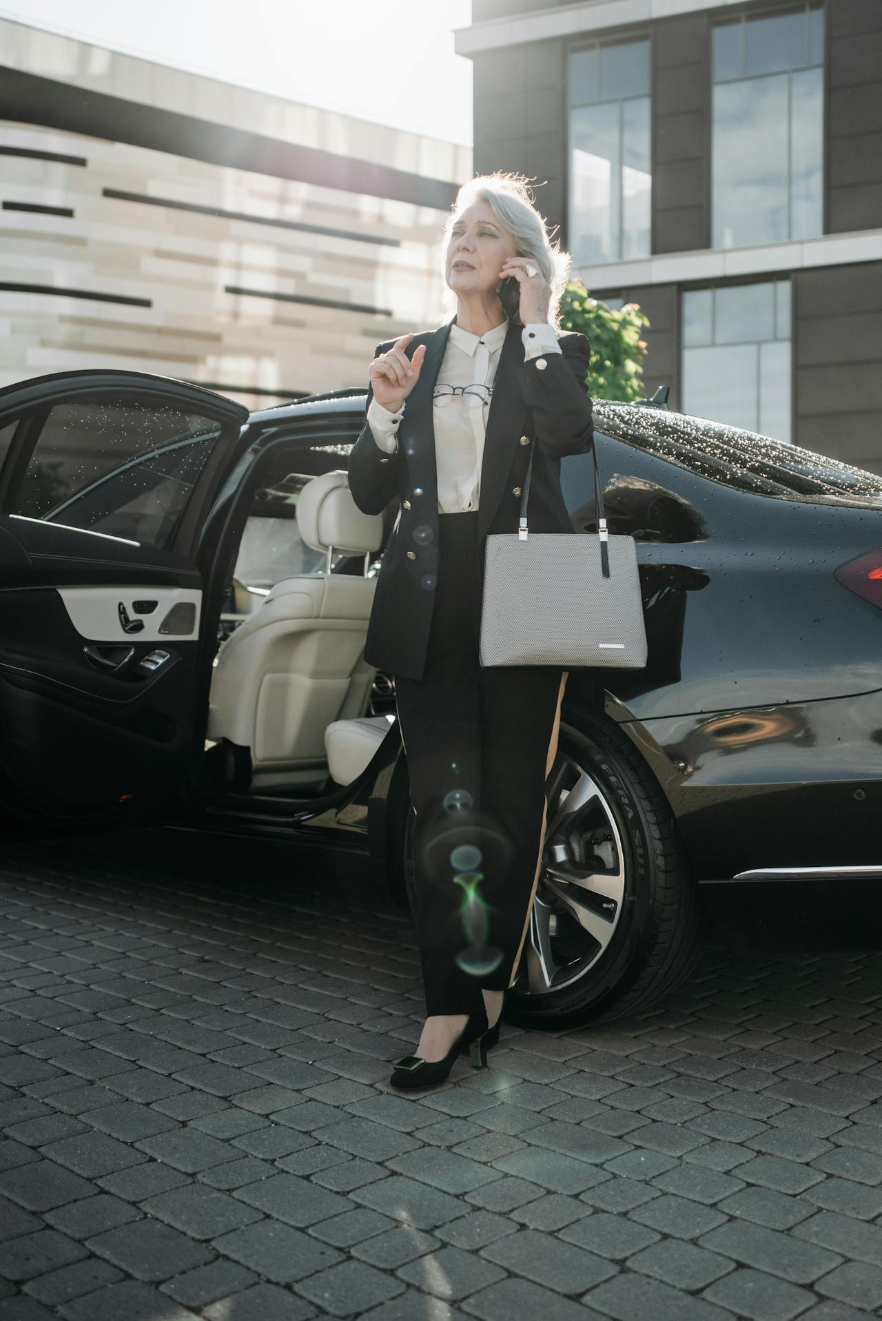 Eine elegante ältere Frau, die neben ihrem Auto steht und telefoniert | Quelle: Pexels