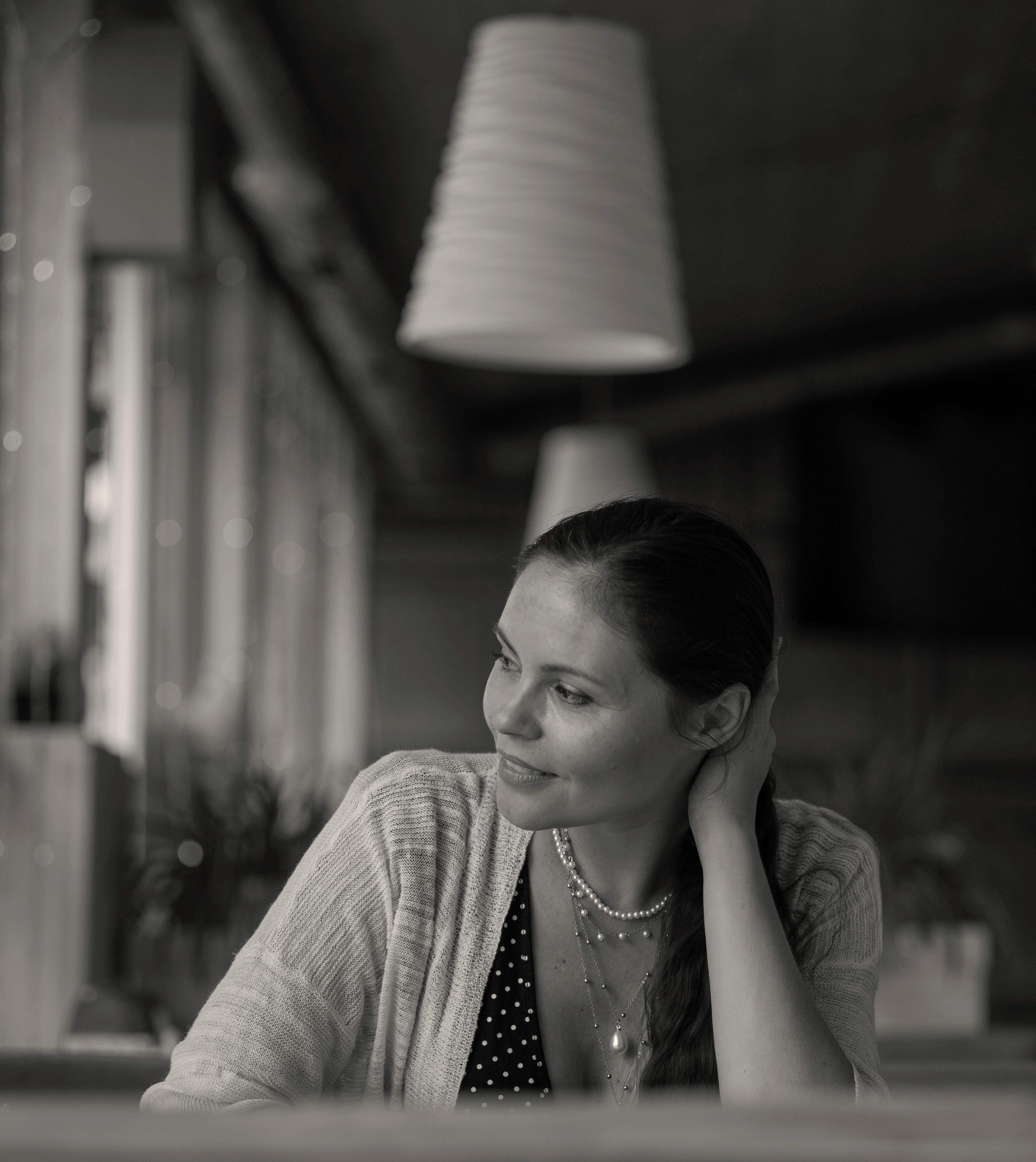 Ein Graustufenfoto von einer Frau, die in einem Restaurant sitzt | Quelle: Pexels