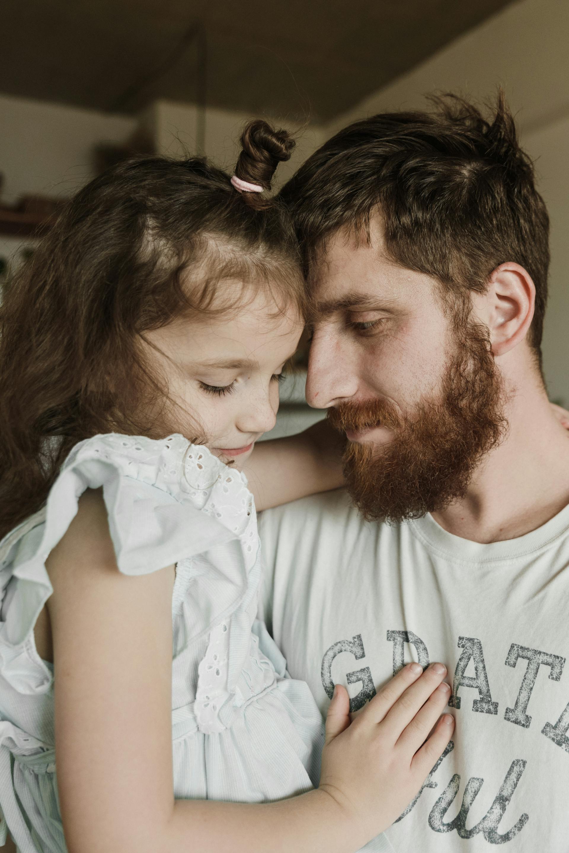 Ein Vater hält seine kleine Tochter im Arm | Quelle: Pexels