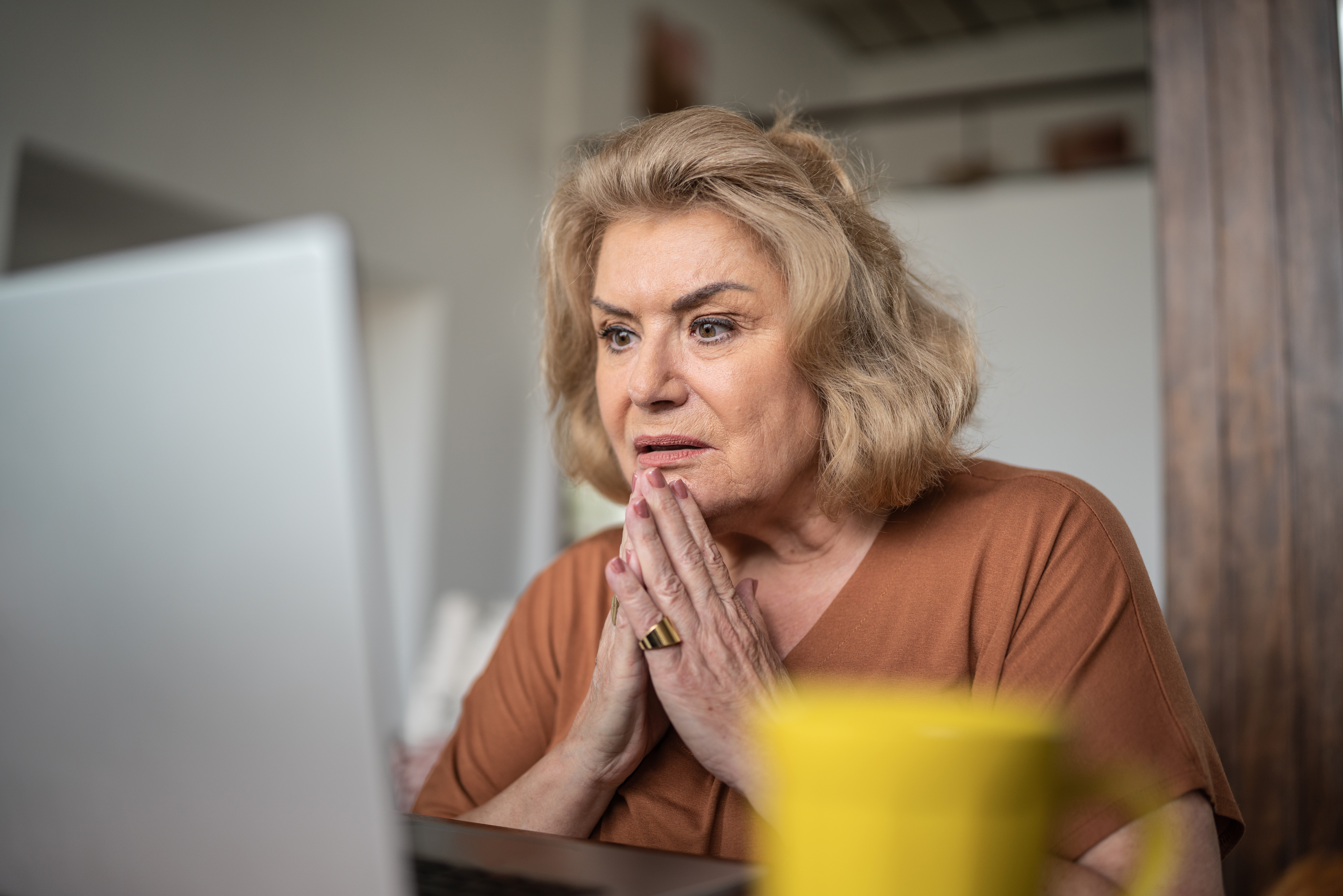 Schockierte ältere Frau, die zu Hause den Laptop benutzt | Quelle: Getty Images