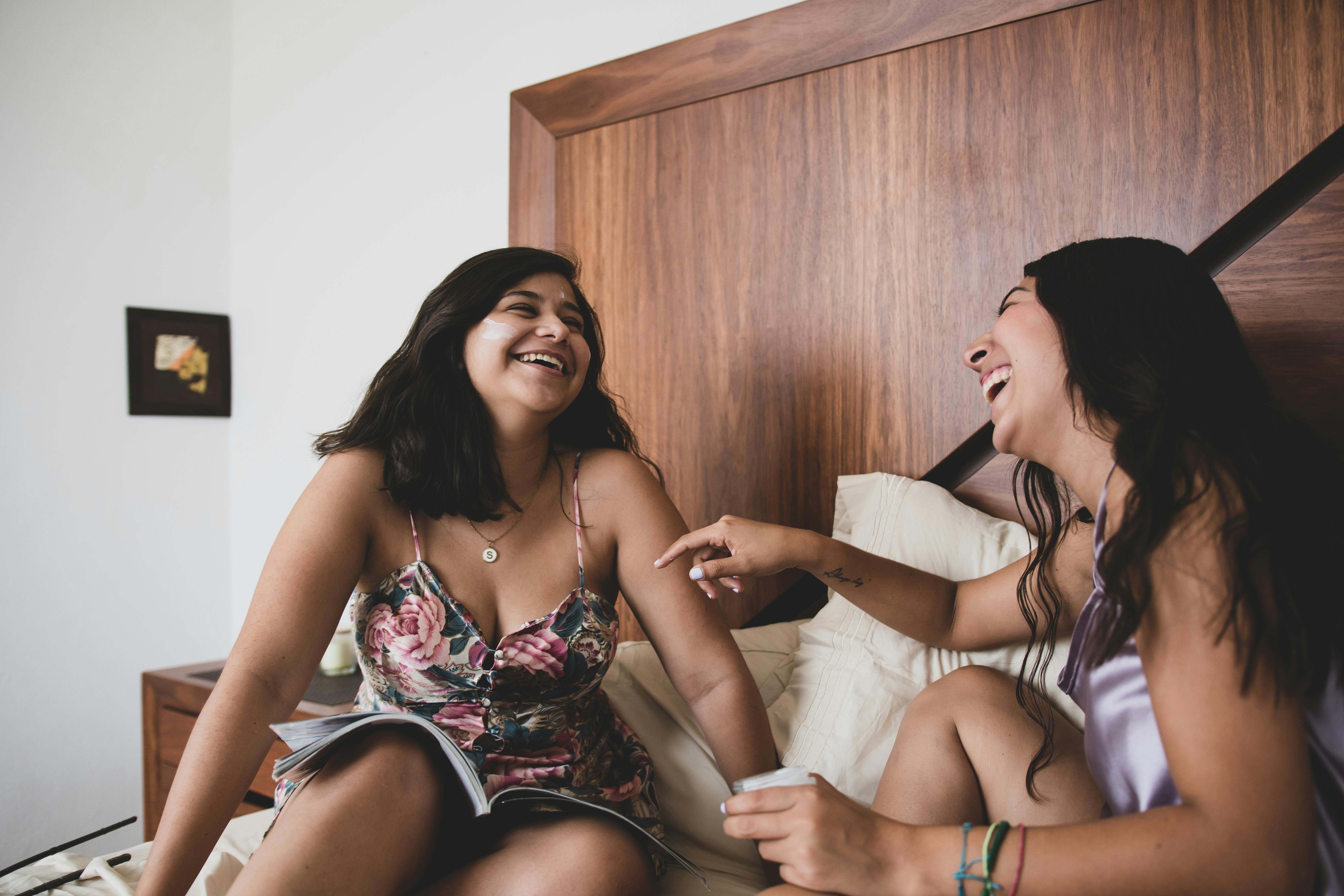 Zwei lachende Frauen auf dem Bett | Quelle: Pexels