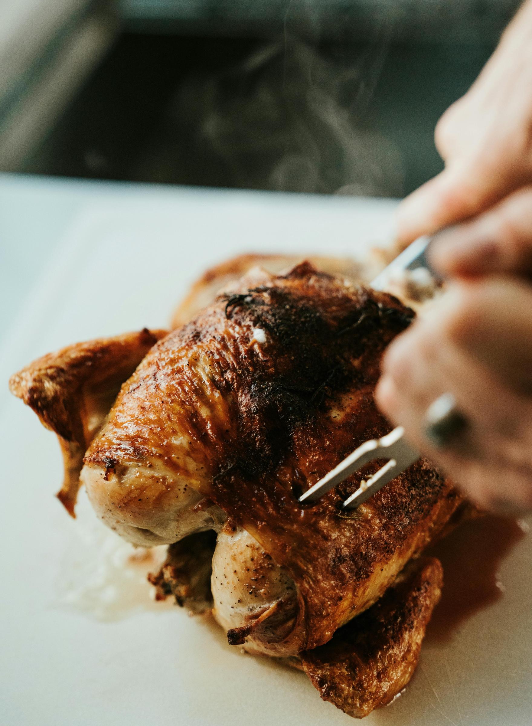 Ein Stück Brathähnchen wird aufgeschnitten | Quelle: Pexels