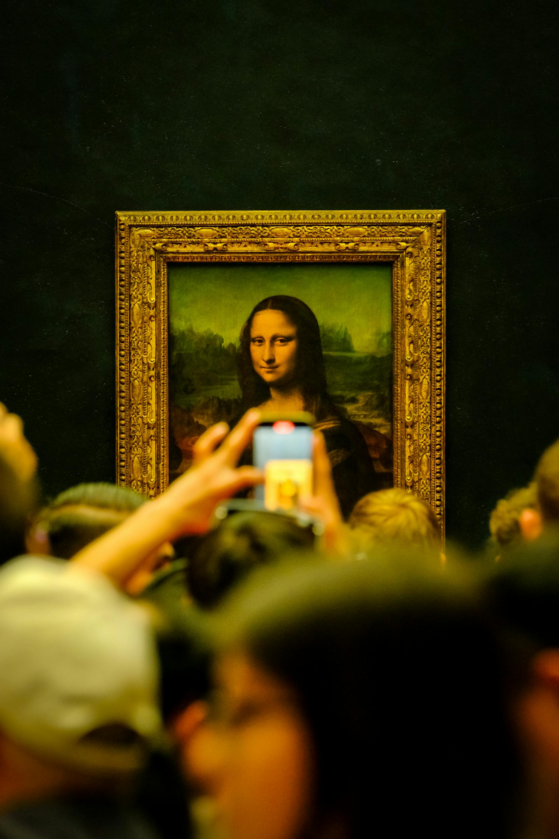 Menschen, die das Gemälde der Mona Lisa in einer Galerie betrachten | Quelle: Pexels