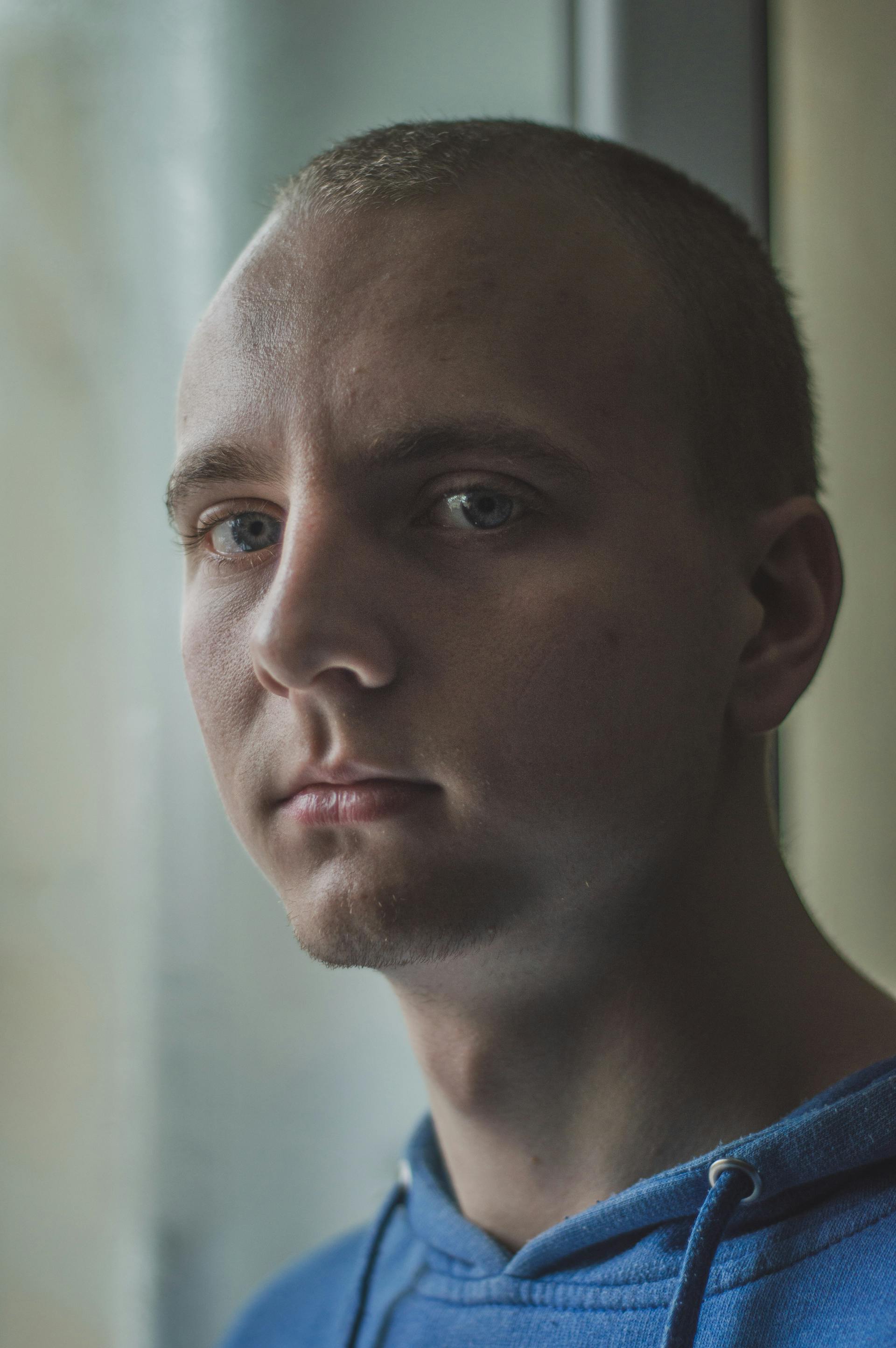 Ein Mann mit kurzen Haaren und blauen Augen blickt nach vorne | Quelle: Pexels
