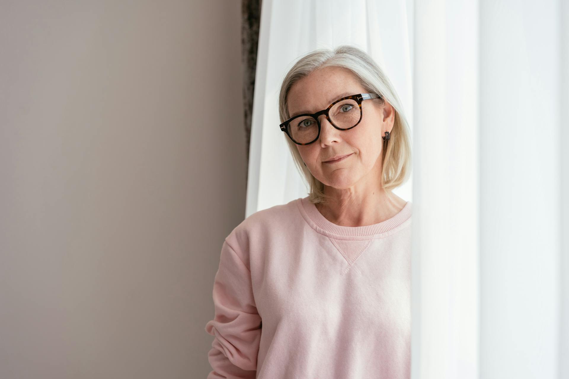 Eine Frau mittleren Alters in einem rosa Pullover mit Brille | Quelle: Pexels