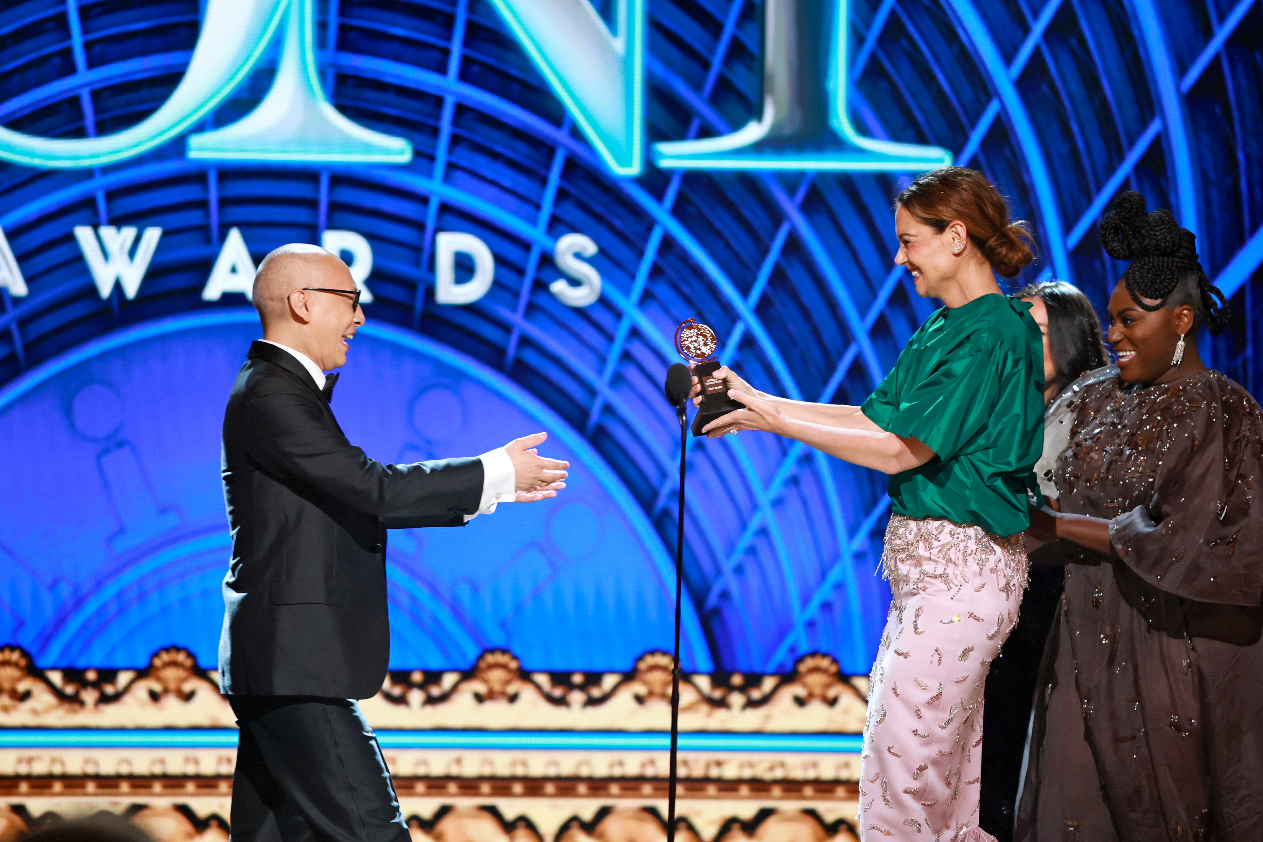 Francis Jue erhält seinen Tony Award für den besten Hauptdarsteller in einem Theaterstück von Katie Holmes und Danielle Brooks. Holmes strahlt, als sie die Trophäe überreicht, und das ist einer der herzlichsten Momente der Zeremonie.