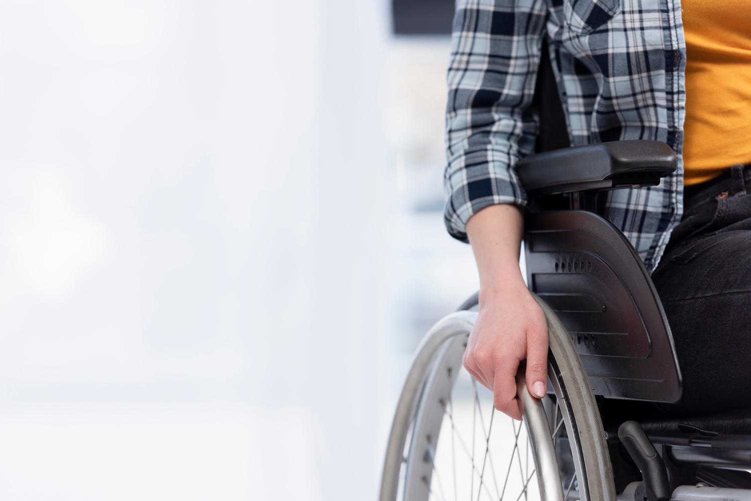 Ausgeschnittene Aufnahme einer Frau, die auf ihrem Rollstuhl sitzt | Quelle: Freepik