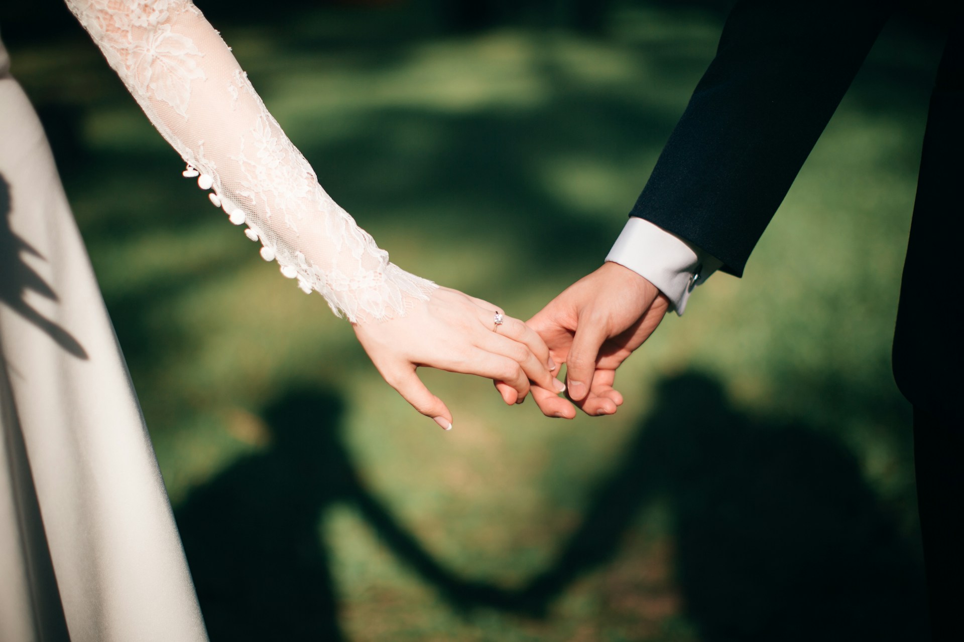 Ein Paar, das an seinem Hochzeitstag Händchen hält | Quelle: Unsplash