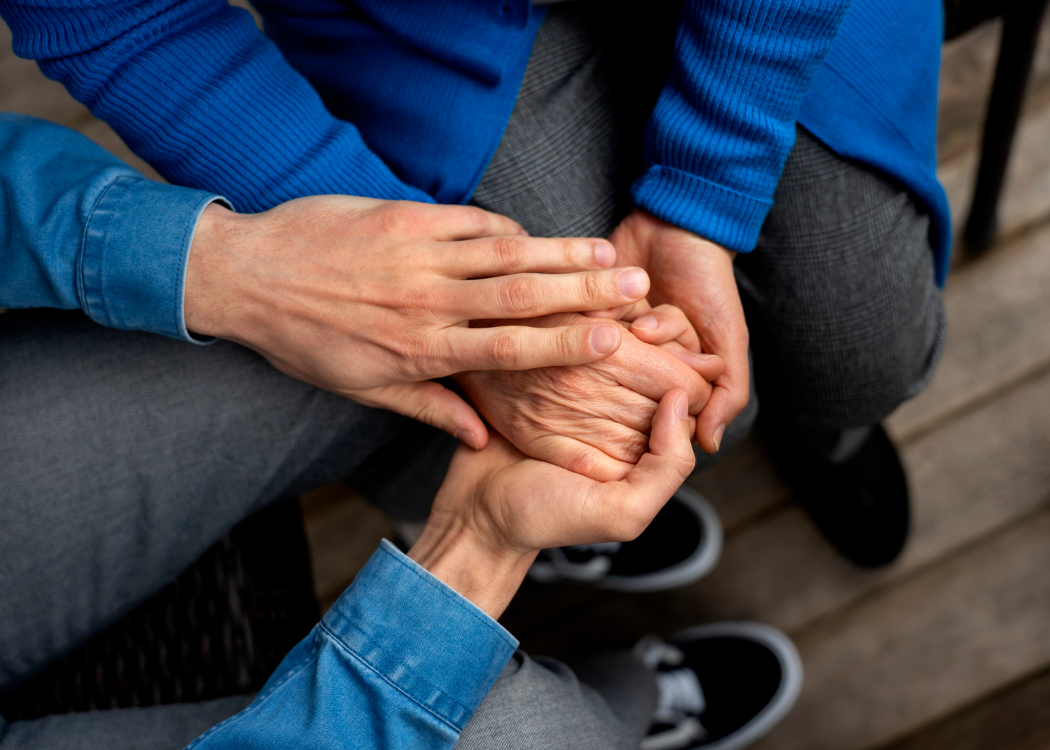 Ein junger Mann hält die Hand einer älteren Person | Quelle: Freepik