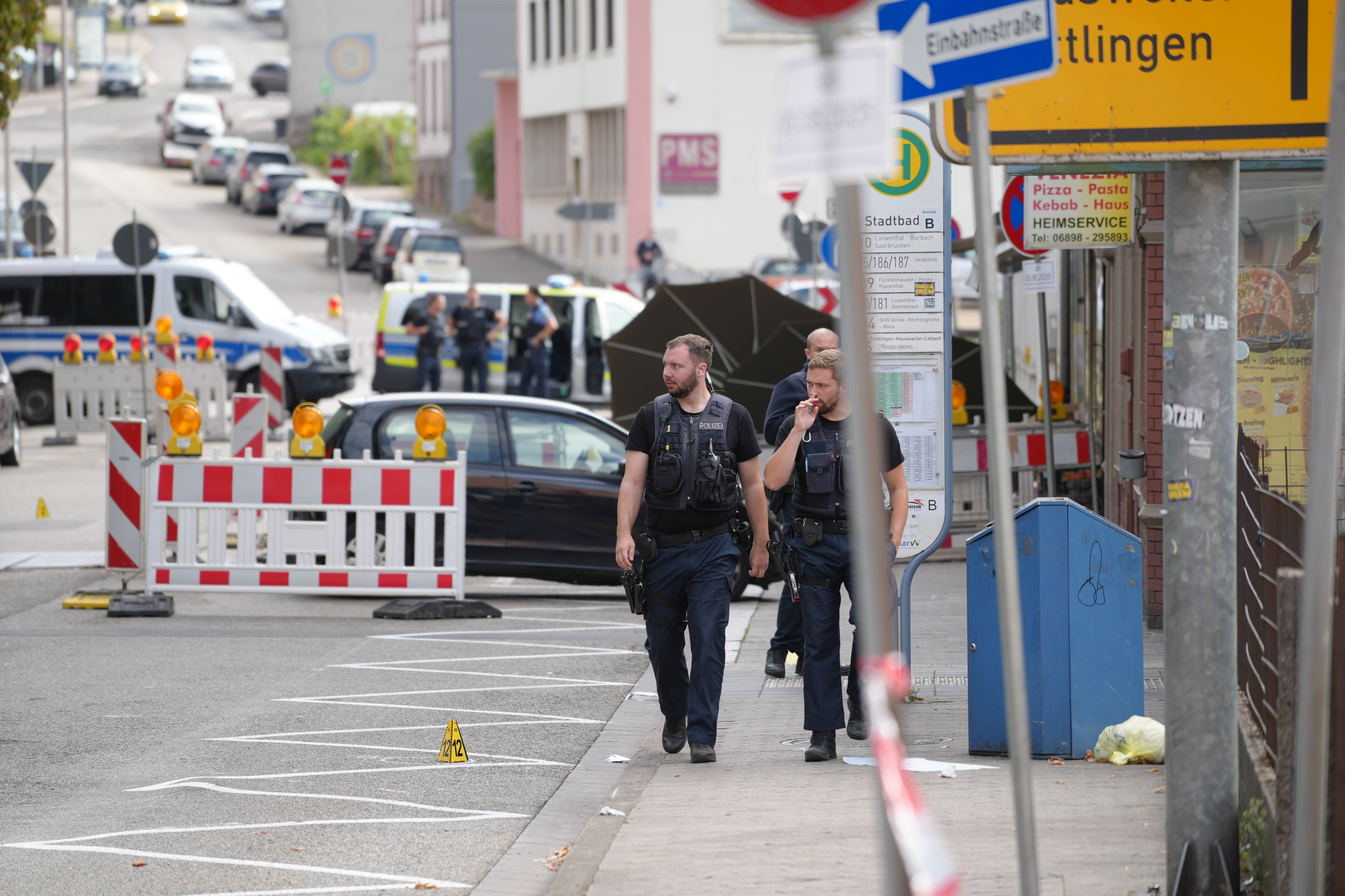 22. August 2025, Saarland, Völklingen: Polizeibeamte untersuchen die Umgebung eines Tatorts. Ein Polizeibeamter wurde nach einem Raubüberfall auf eine Tankstelle in Völklingen, Saarland, durch Schüsse getötet. Nach Angaben der Polizei entriss der mutmaßliche Täter dem Beamten während eines Handgemenges dessen Dienstwaffe und schoss. | Quelle: Getty Images