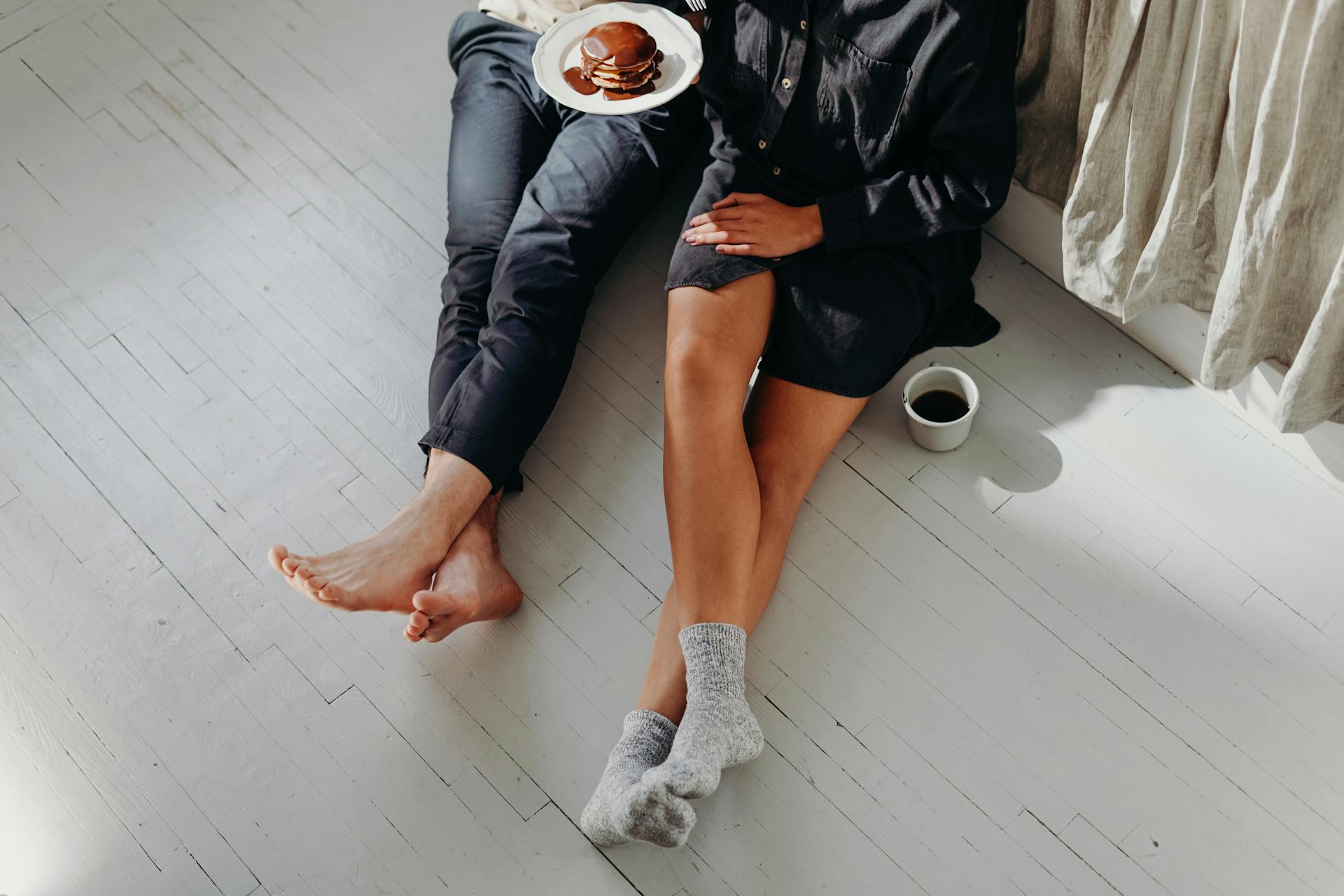 Eine Nahaufnahme eines Paares beim Frühstück auf dem Boden | Quelle: Pexels