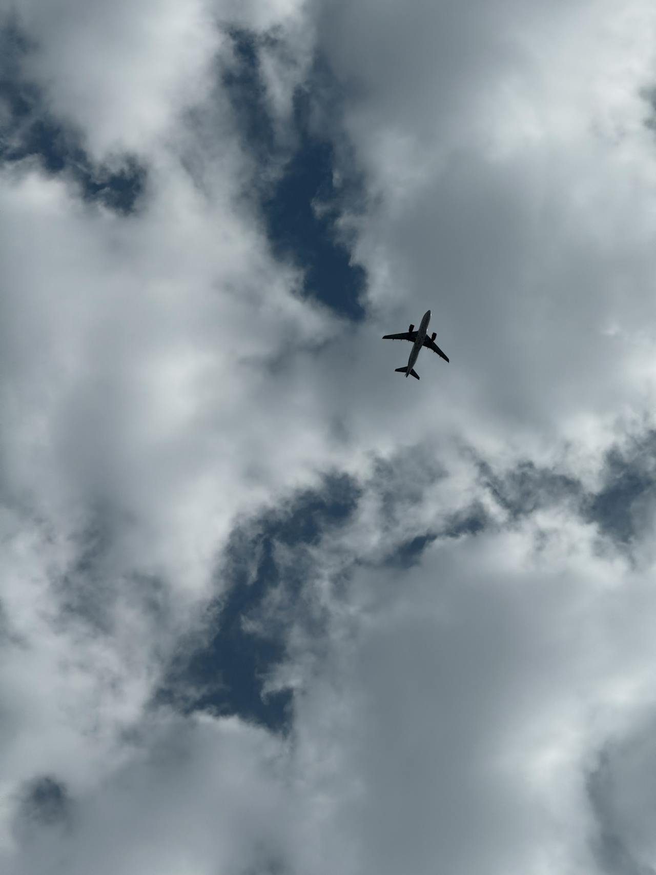 Ein Flugzeug fliegt über einen bewölkten Himmel | Quelle: Pexels