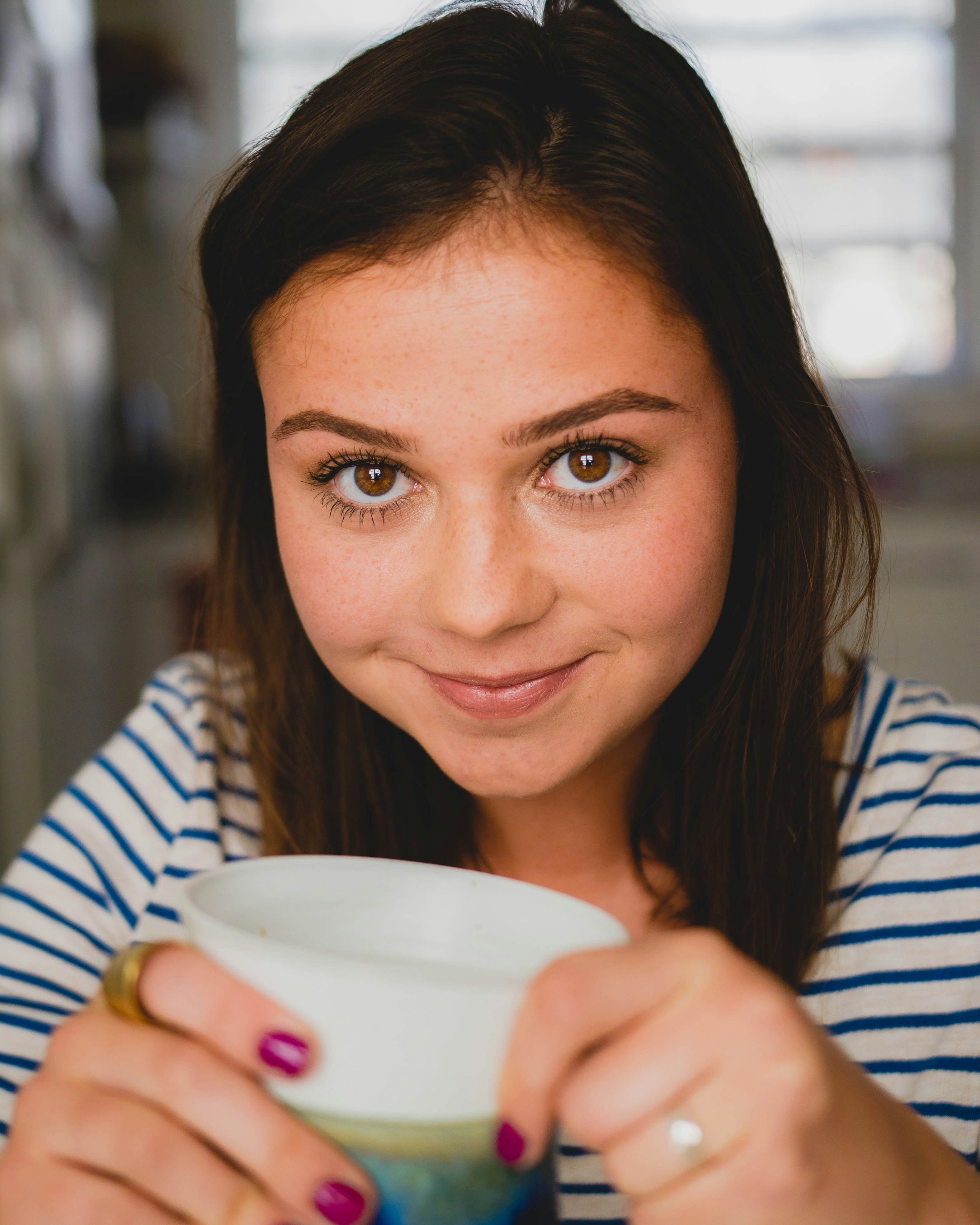 Ein glückliches Mädchen hält einen Becher | Quelle: Unsplash