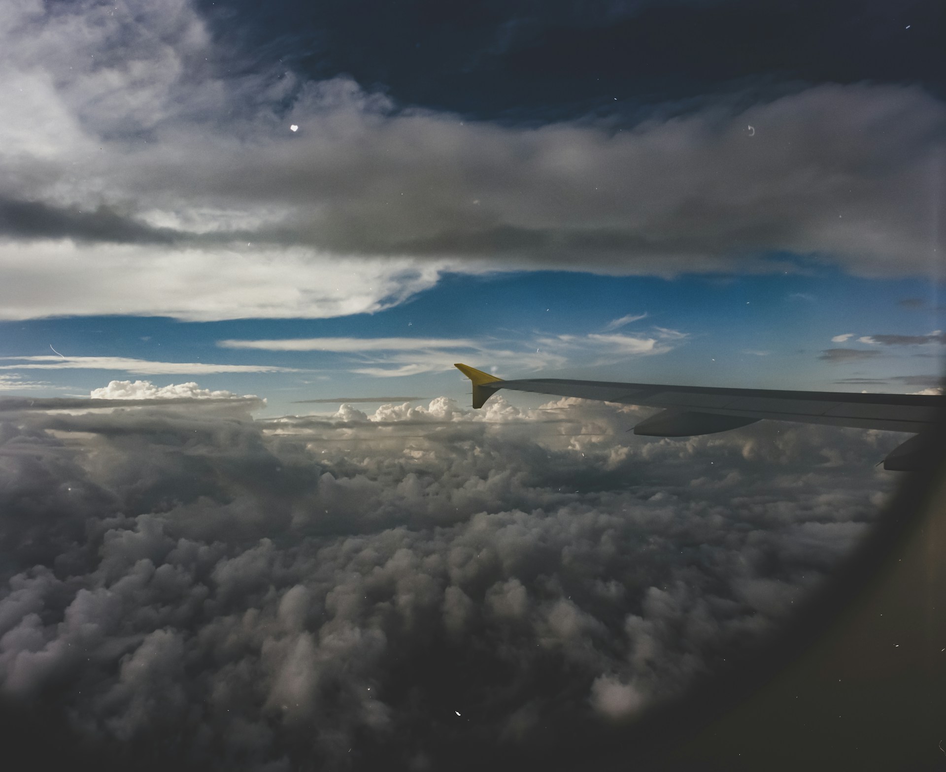 Ein Blick auf die Wolken durch ein Flugzeugfenster | Quelle: Unsplash