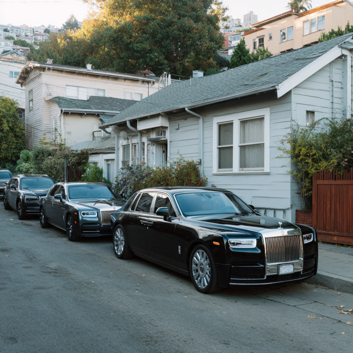 Mehrere schwarze Rolls-Royce säumen die Straße | Quelle: Midjourney
