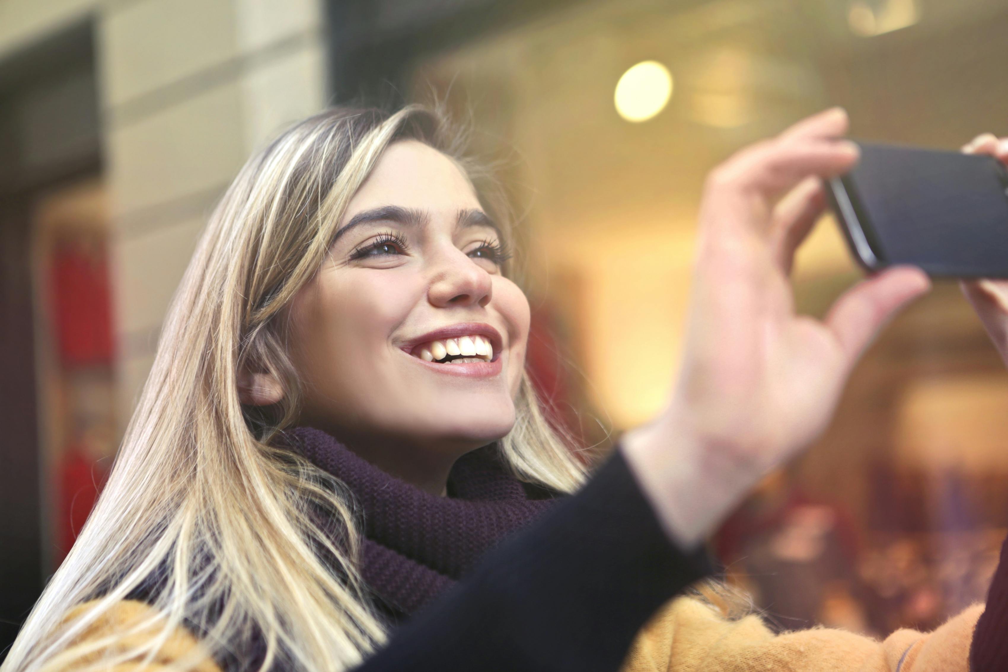 Eine glückliche Frau beim Fotografieren | Quelle: Pexels
