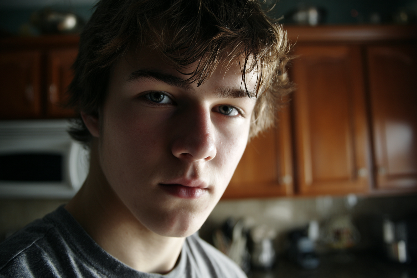 Ein Teenager steht in der Küche und schaut jemanden an | Quelle: Midjourney