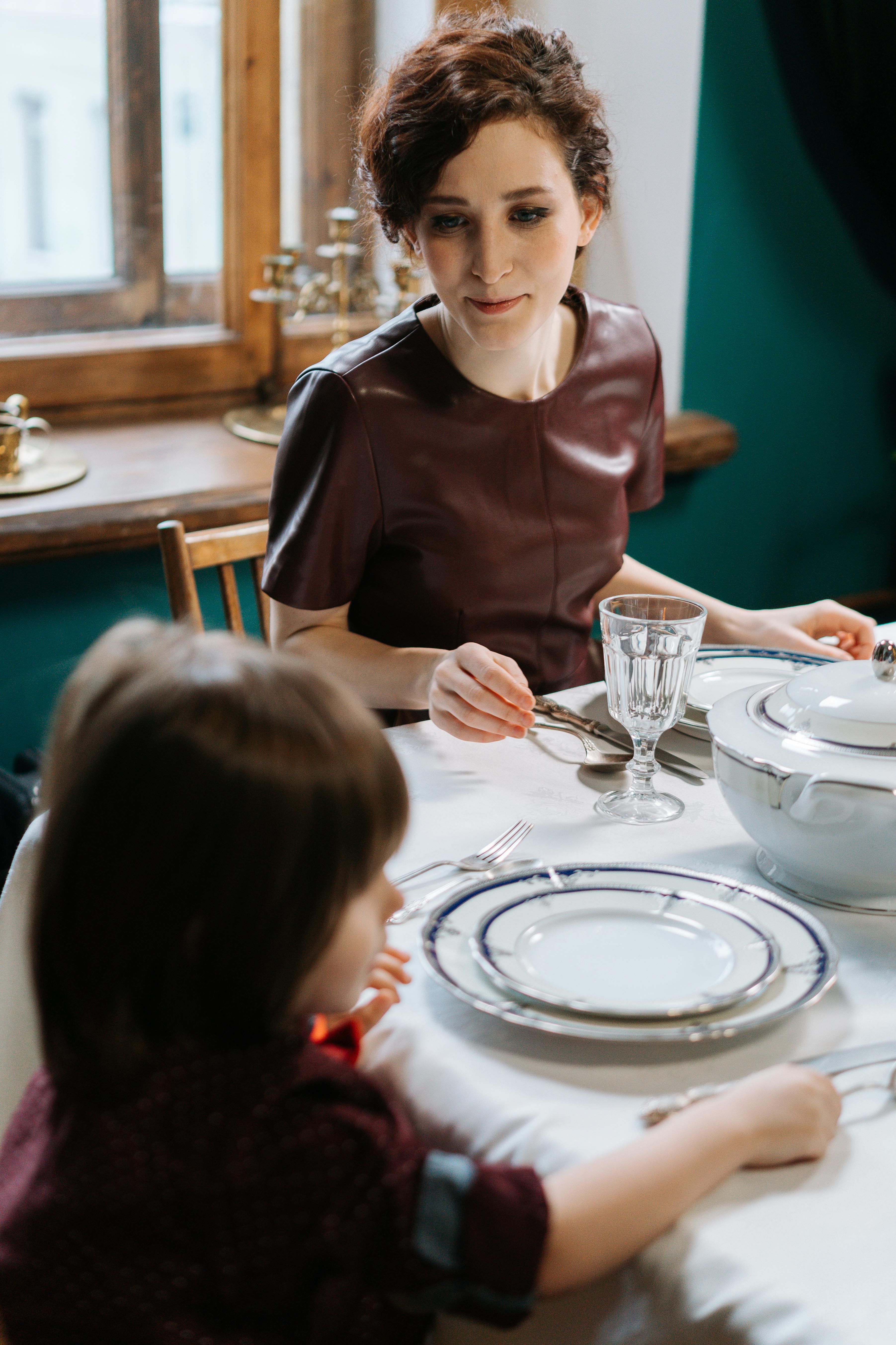Kindermädchen schaut auf einen Jungen, der neben ihr sitzt Quelle: Pexels