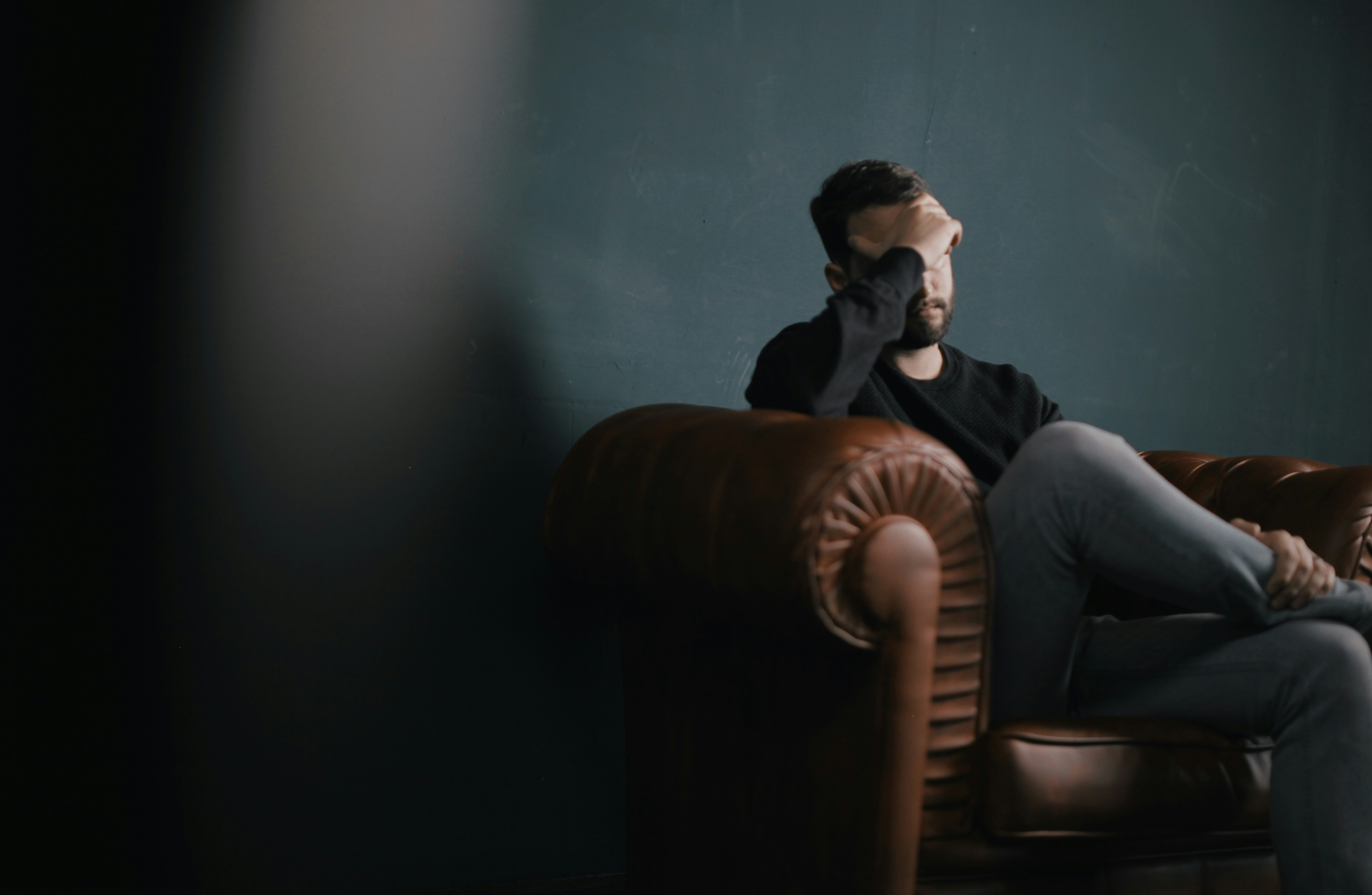 Ein gestresster Mann sitzt auf einer Couch | Quelle: Unsplash