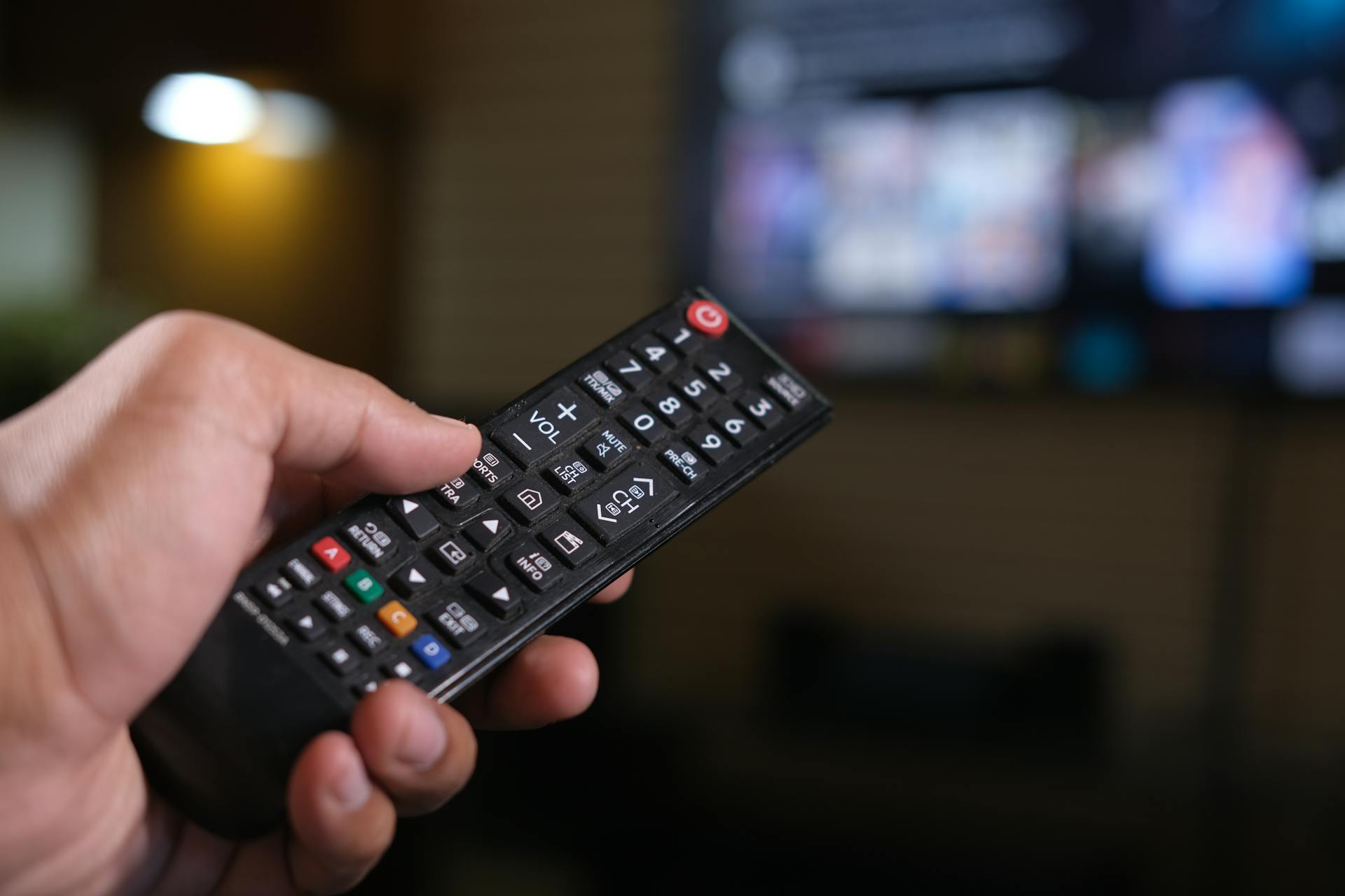 Mann hält eine TV-Fernbedienung | Quelle: Pexels