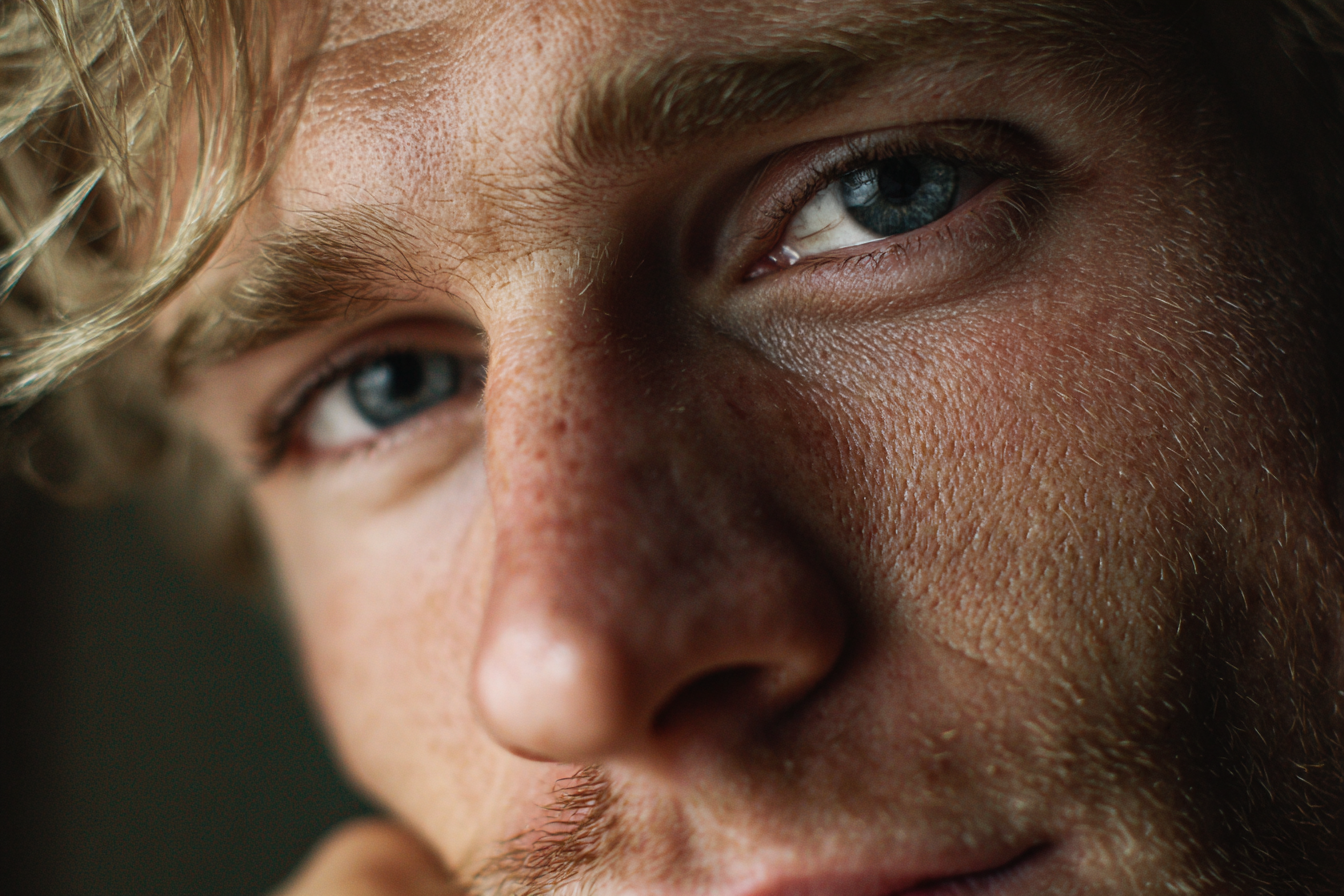 Ein Mann mit einem emotionalen Blick in den Augen, der jemanden schwach anlächelt | Quelle: Midjourney