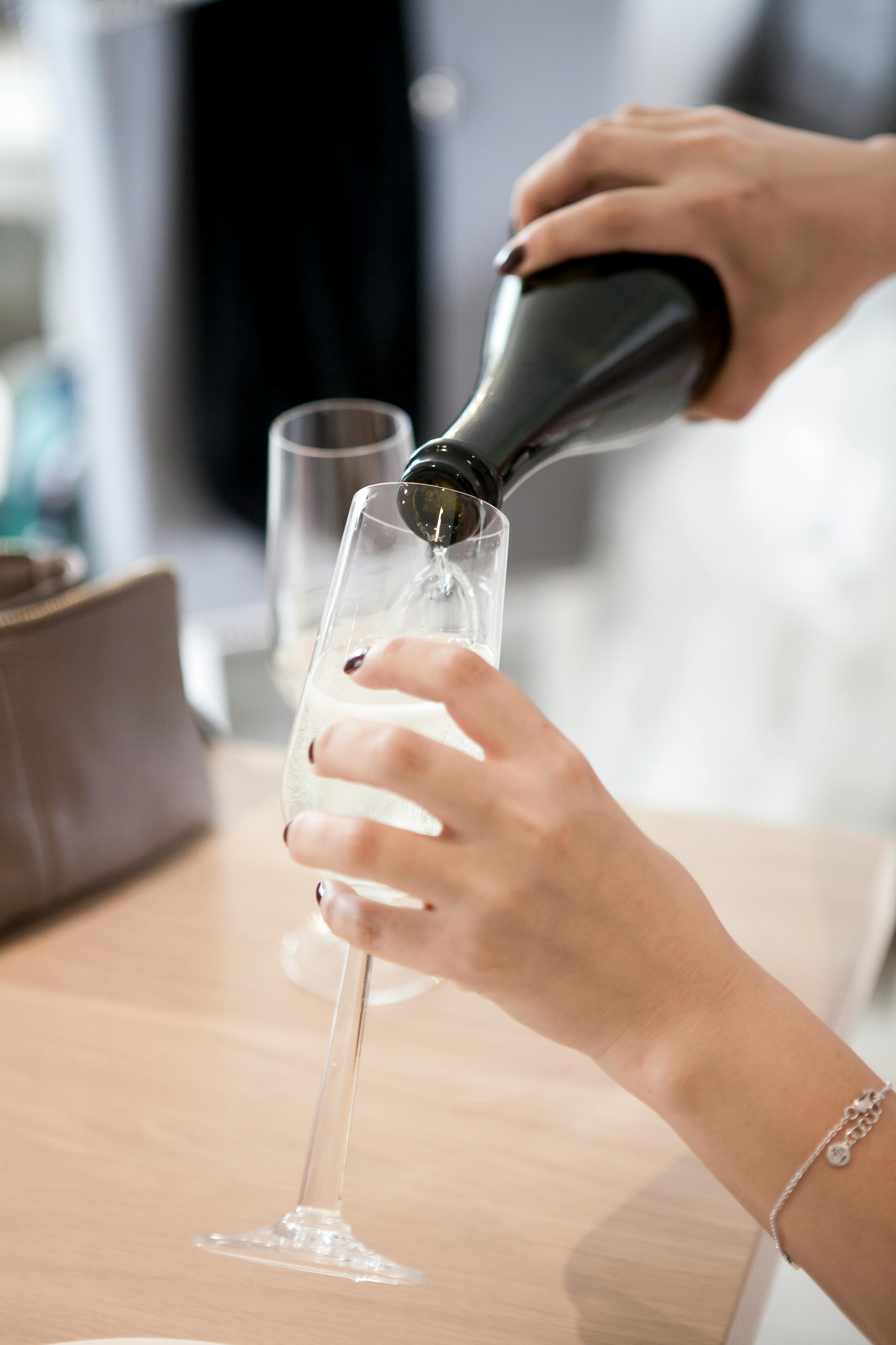 Eine Person gießt ein Glas Champagner ein | Quelle: Pexels