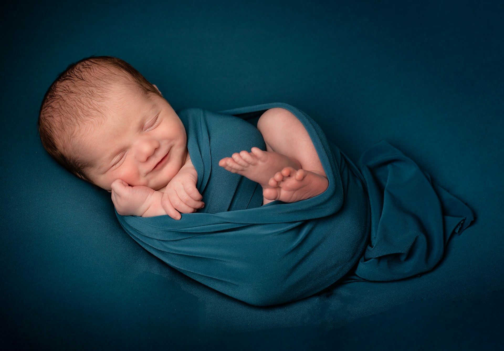 Ein süßes Baby, eingewickelt in eine blaue Decke | Quelle: Unsplash