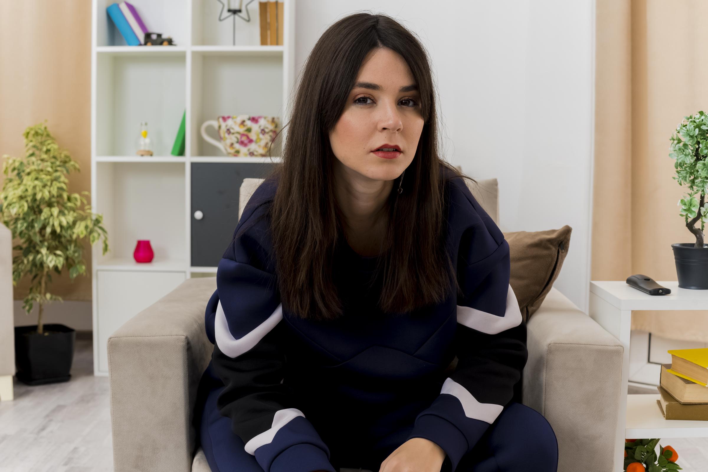 Eine wütende junge Frau sitzt auf der Couch | Quelle: Freepik
