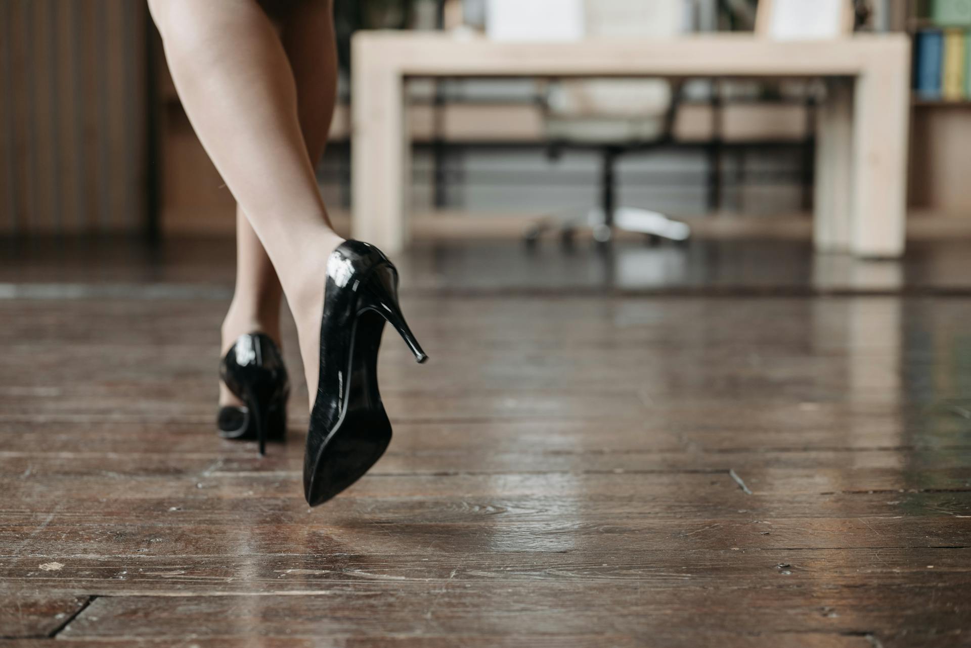 Eine Frau in schwarzen Stöckelschuhen geht in einen Raum | Quelle: Pexels