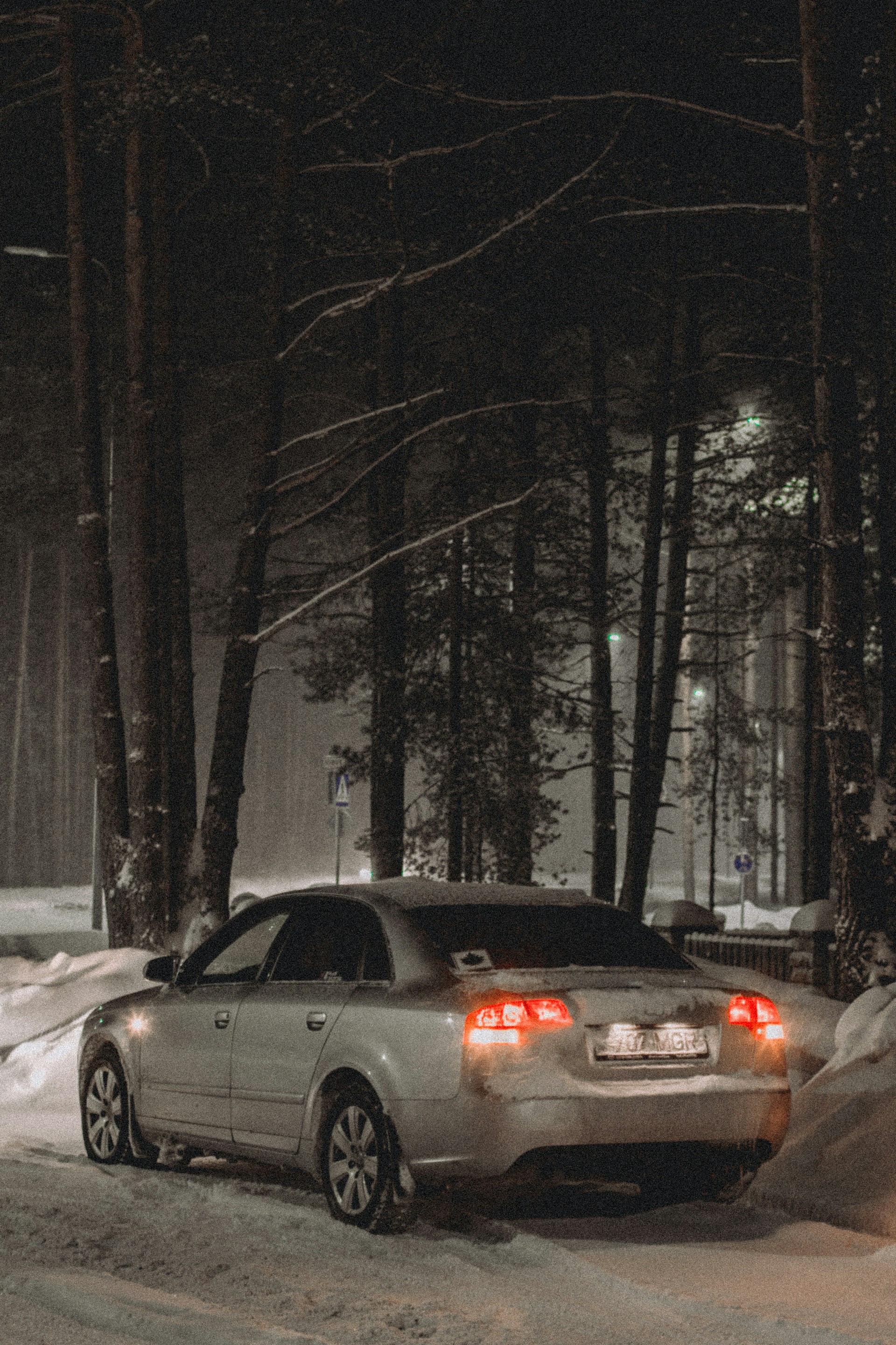 Ein Auto im Wald an einem verschneiten Abend | Quelle: Unsplash