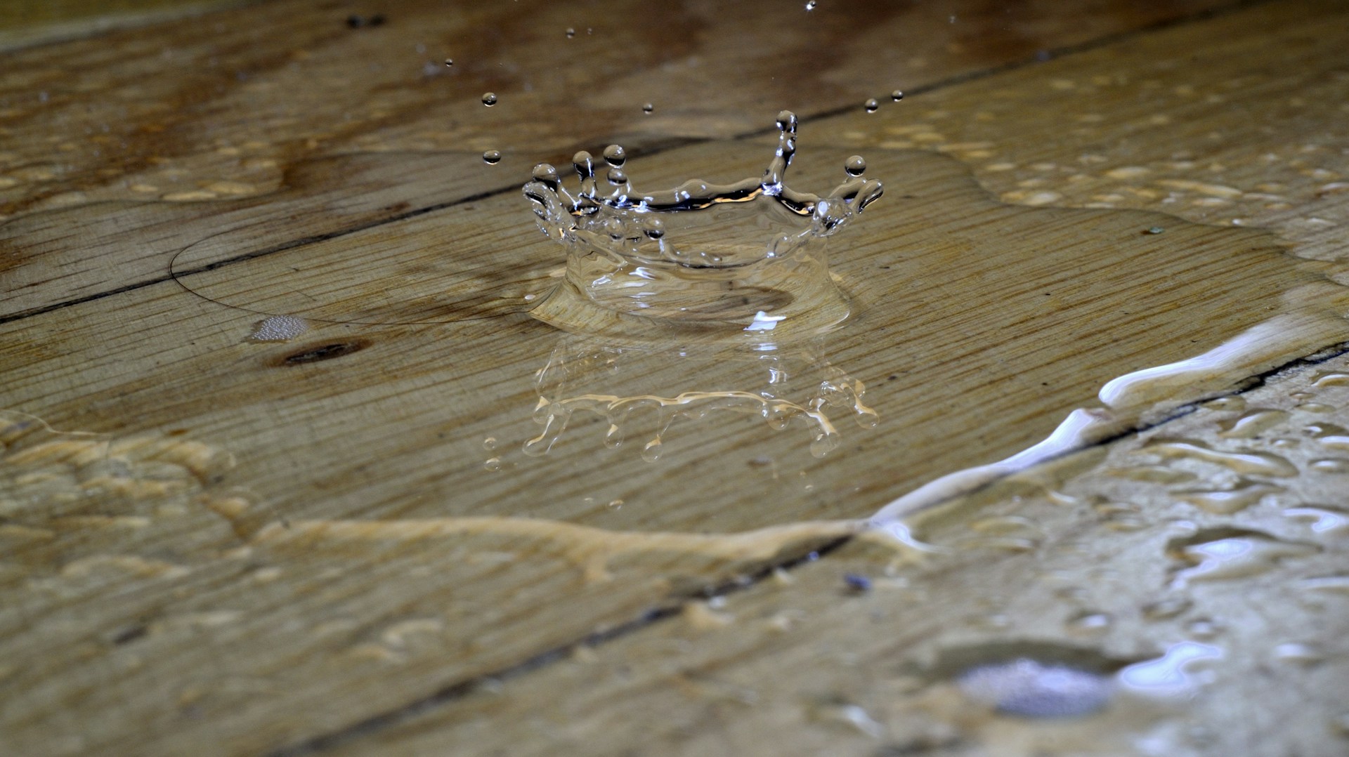 Eine Wasserpfütze auf einem Holzboden | Quelle: Unsplash