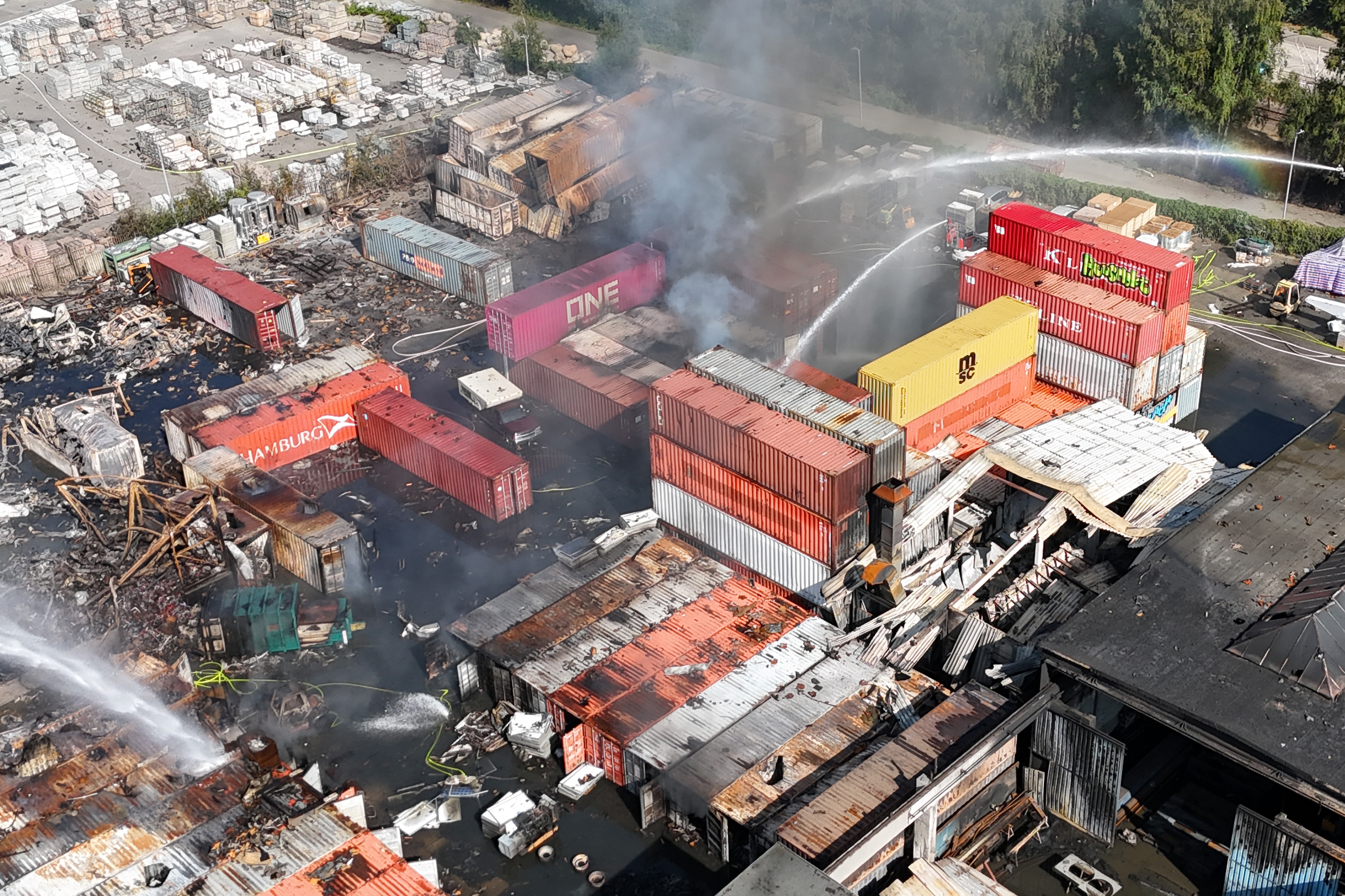 26. August 2025, Hamburg: Feuerwehrleute löschen einen Brand in einem Industriegebiet im Hamburger Hafen, wo am Vortag ein Großbrand ausgebrochen war. | Quelle: Getty Images