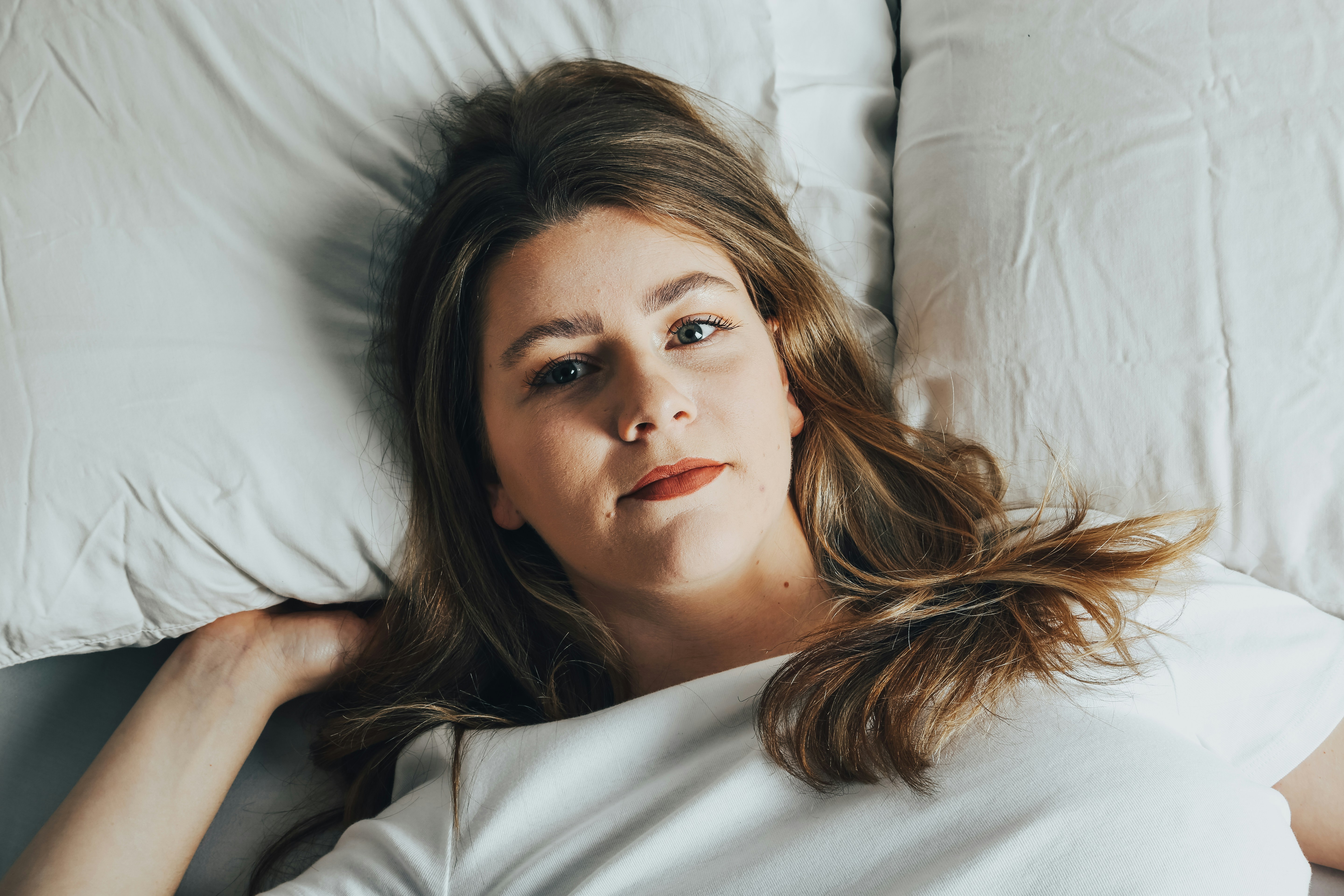 Ein Teenager-Mädchen liegt im Bett | Quelle: Unsplash