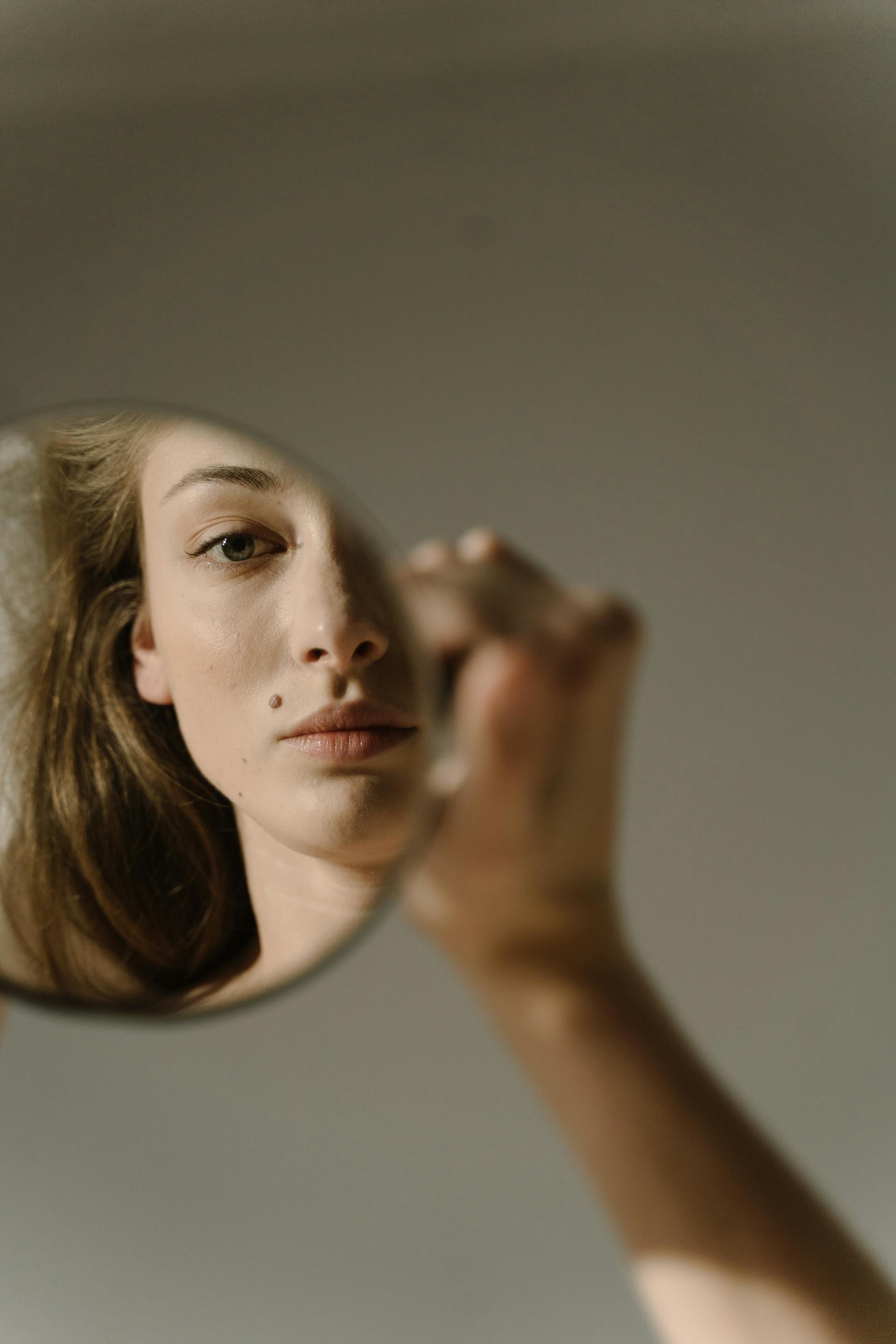 Eine Frau, die ihr Spiegelbild betrachtet | Quelle: Pexels