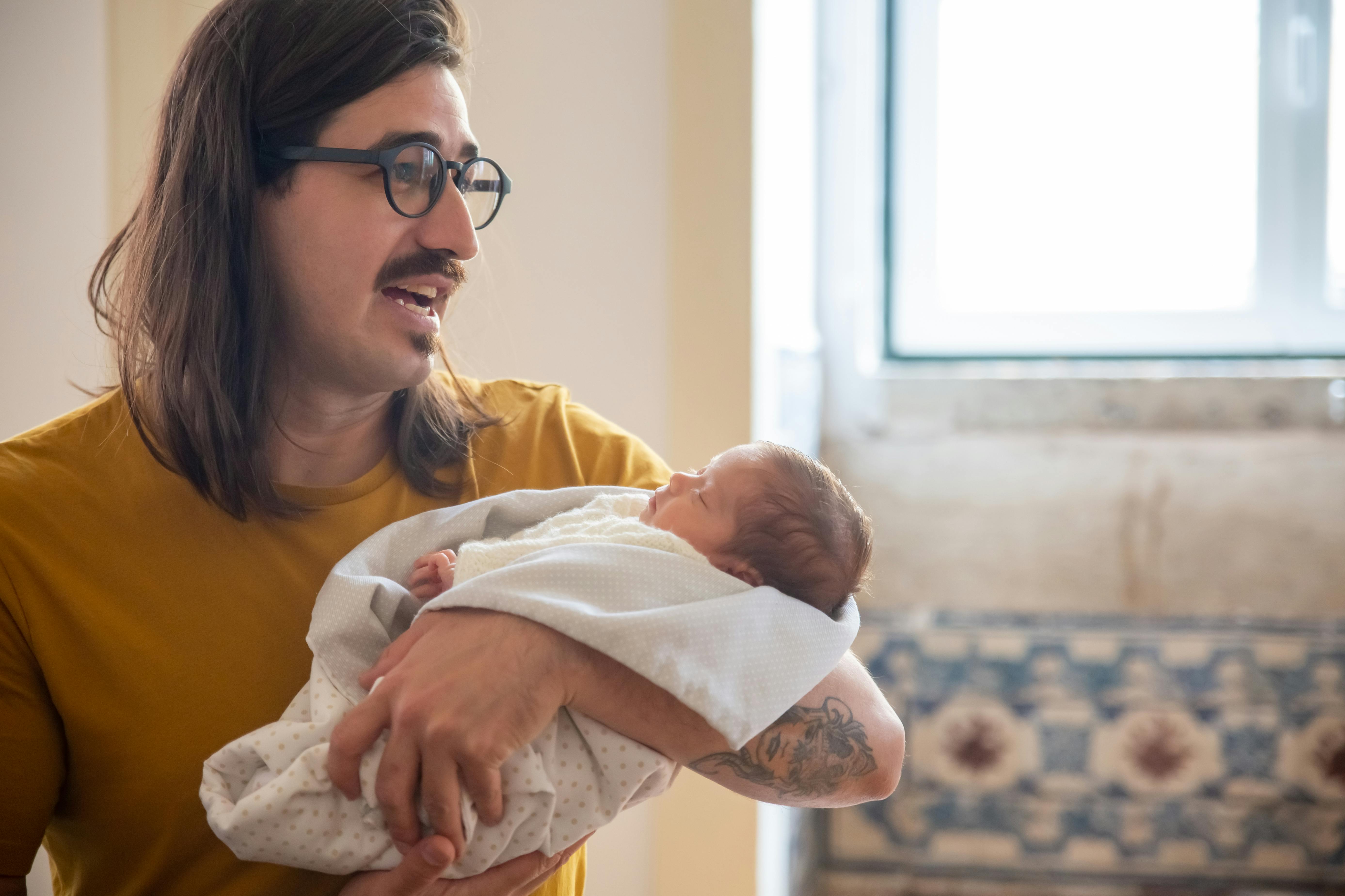 Ein Mann, der ein Baby in den Arm nimmt | Quelle: Pexels