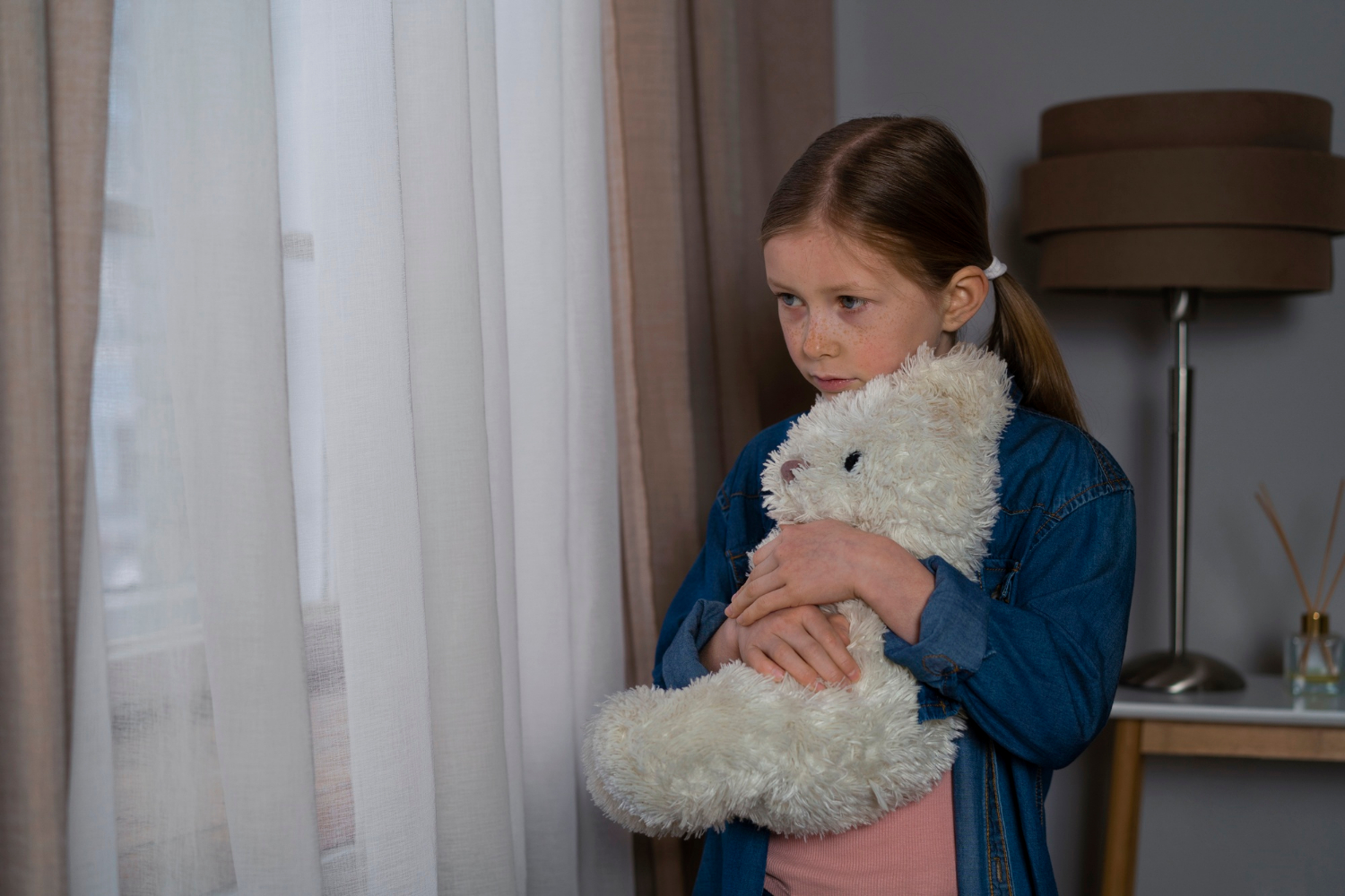 Ein trauriges junges Mädchen hält einen Teddybär | Quelle: Freepik