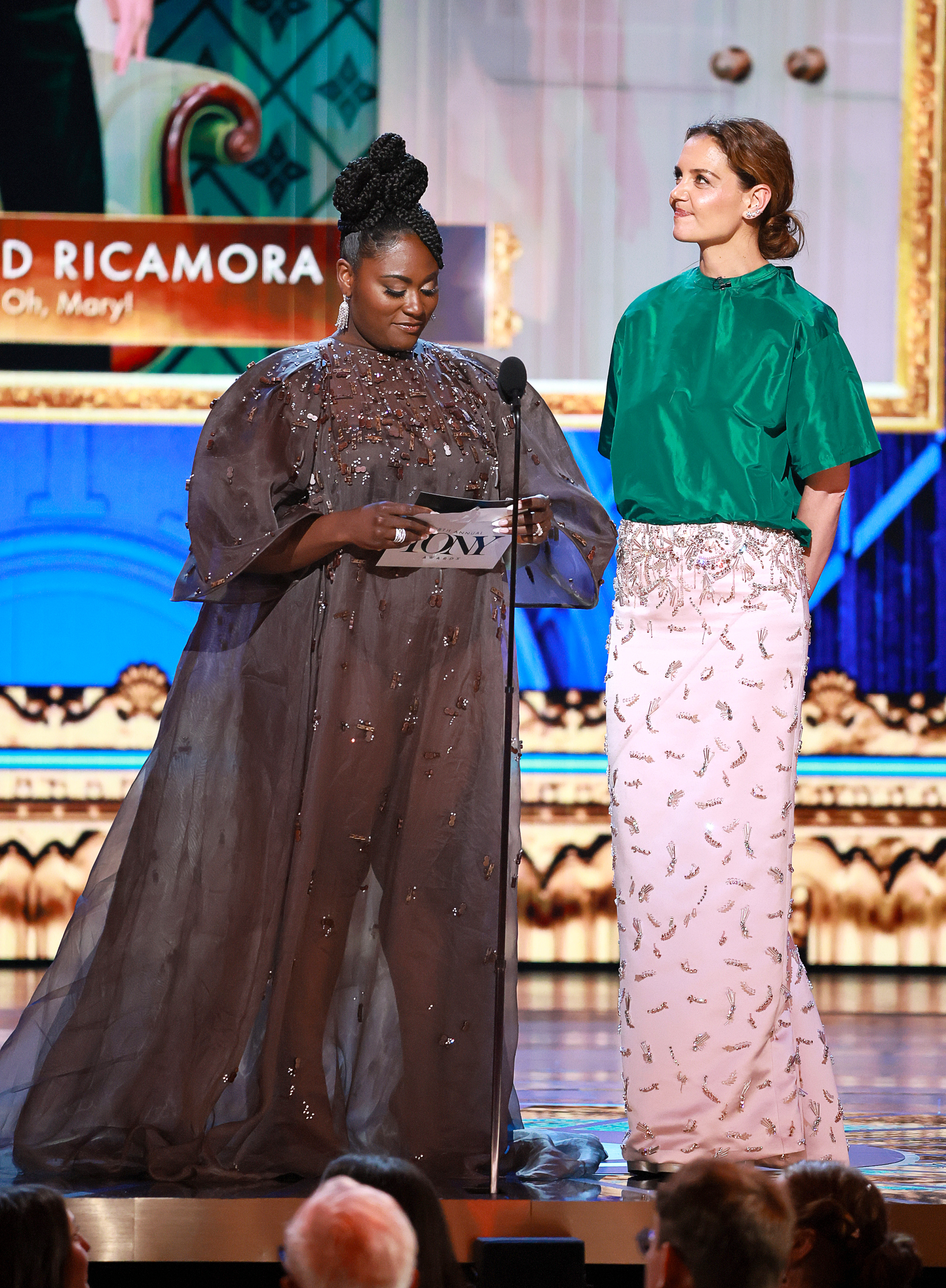 In einem leuchtenden Kontrast aus Grün und zartem Rosa steht Katie Holmes neben Danielle Brooks, als sie bei den Tonys 2025 einen Preis überreicht, und fängt das Rampenlicht mit Farbe und Selbstbewusstsein ein.