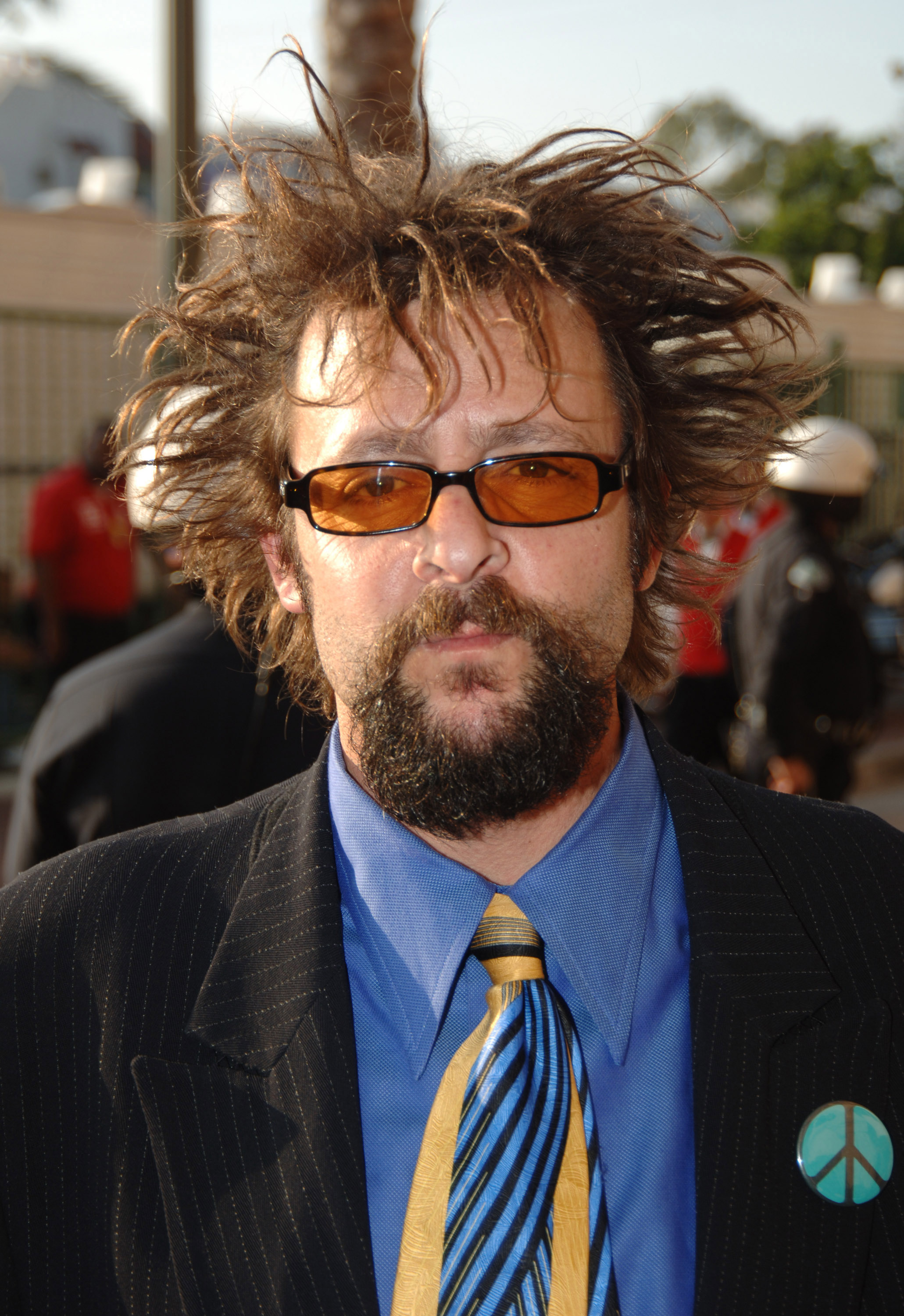 Mit einer markanten, stacheligen Frisur, einer orangefarbenen Sonnenbrille und einem Peace-Zeichen-Anstecker an seinem Sakko präsentierte der Star auf dem roten Teppich bei den MTV Movie Awards 2005 in Los Angeles einen gewagten Look. | Quelle: Getty Images