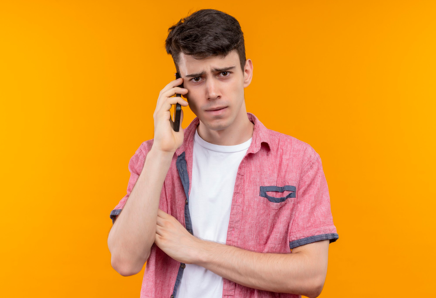 Ein verärgerter junger Mann beim Telefonieren | Quelle: Freepik