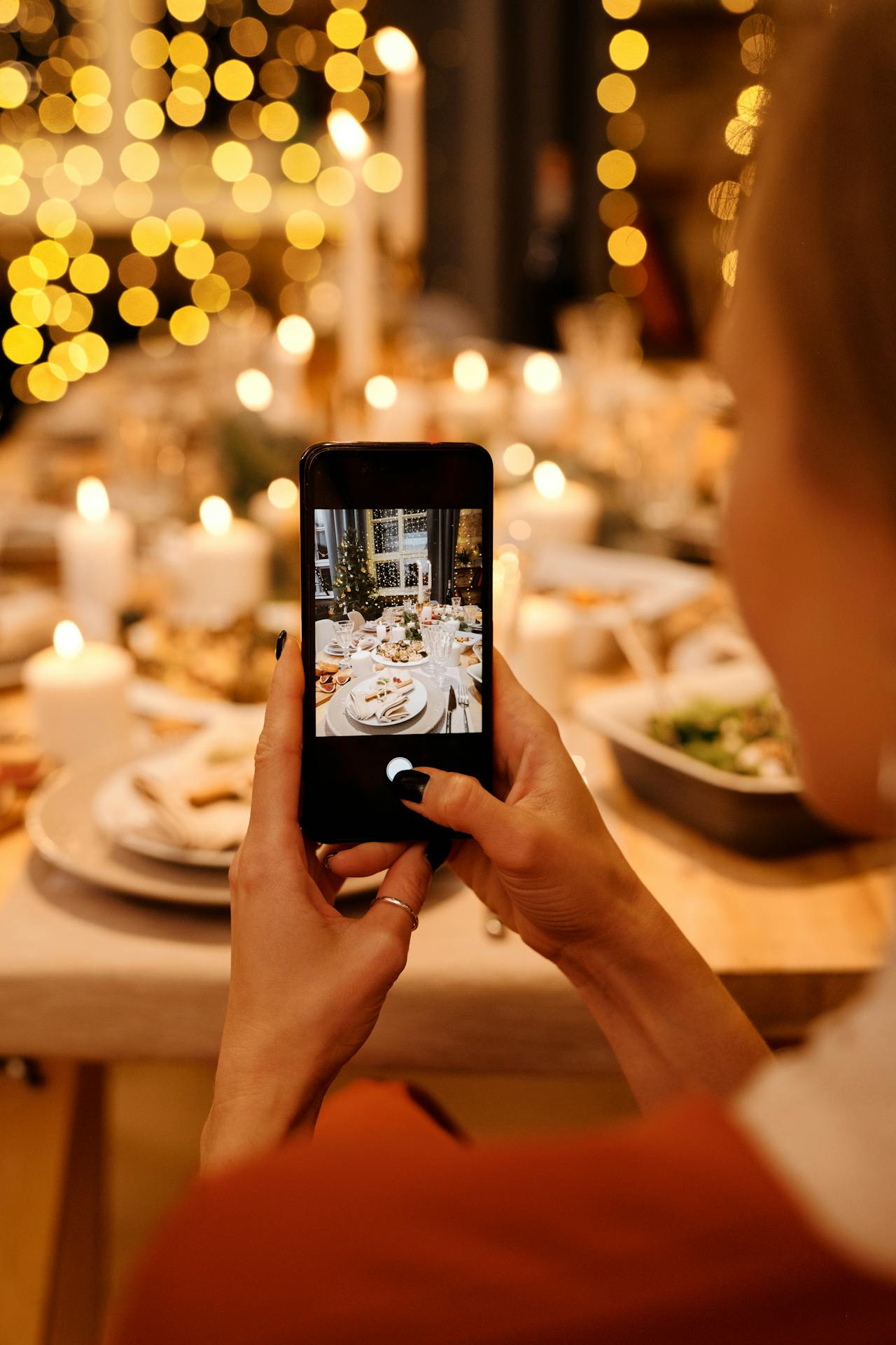 Eine Frau, die ein Foto vom Essen auf dem Tisch macht | Quelle: Pexels