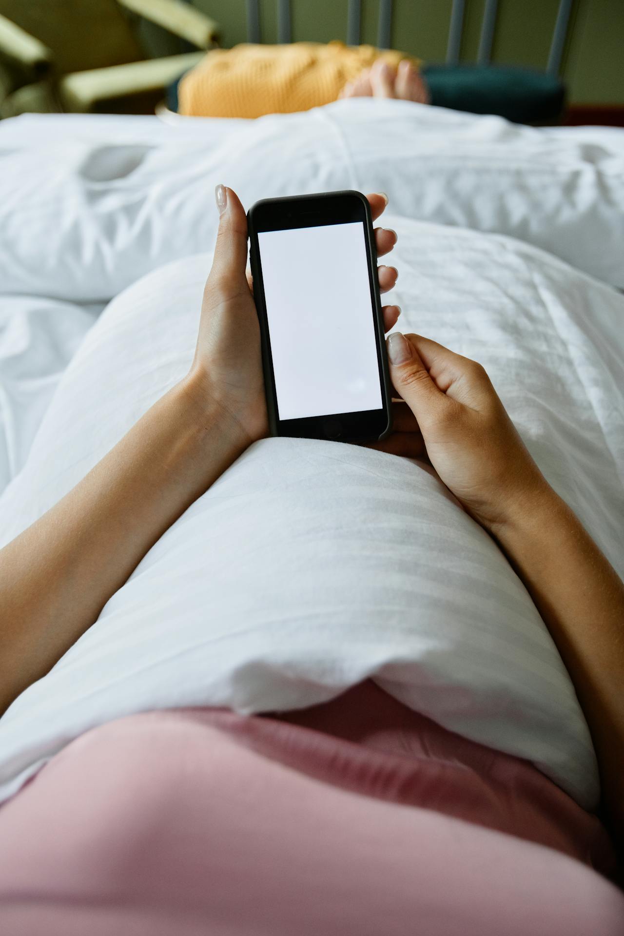Eine Frau benutzt ihr Telefon im Bett | Quelle: Pexels