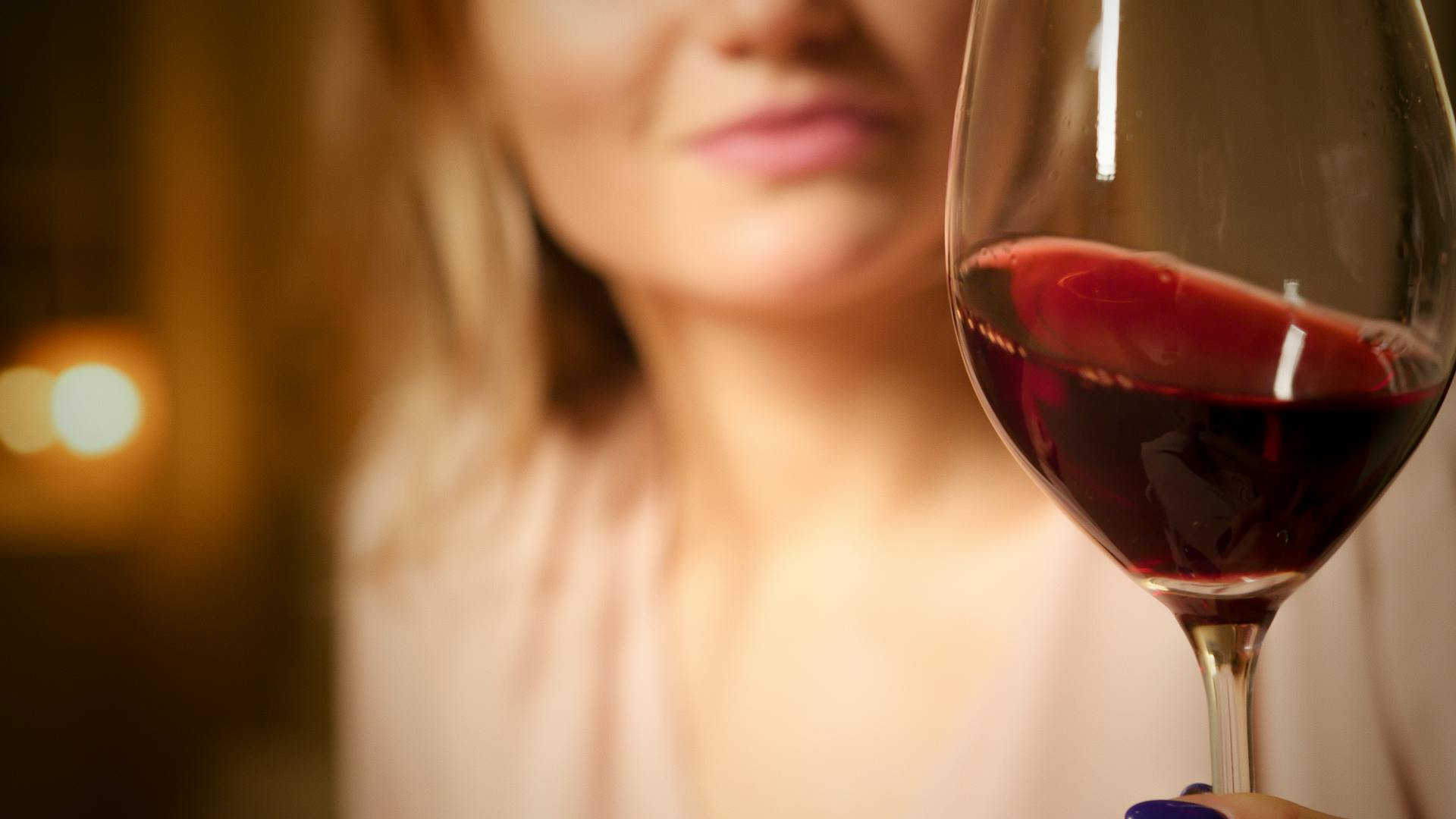 Eine Nahaufnahme einer Frau, die ein Glas Wein hält | Quelle: Pexels