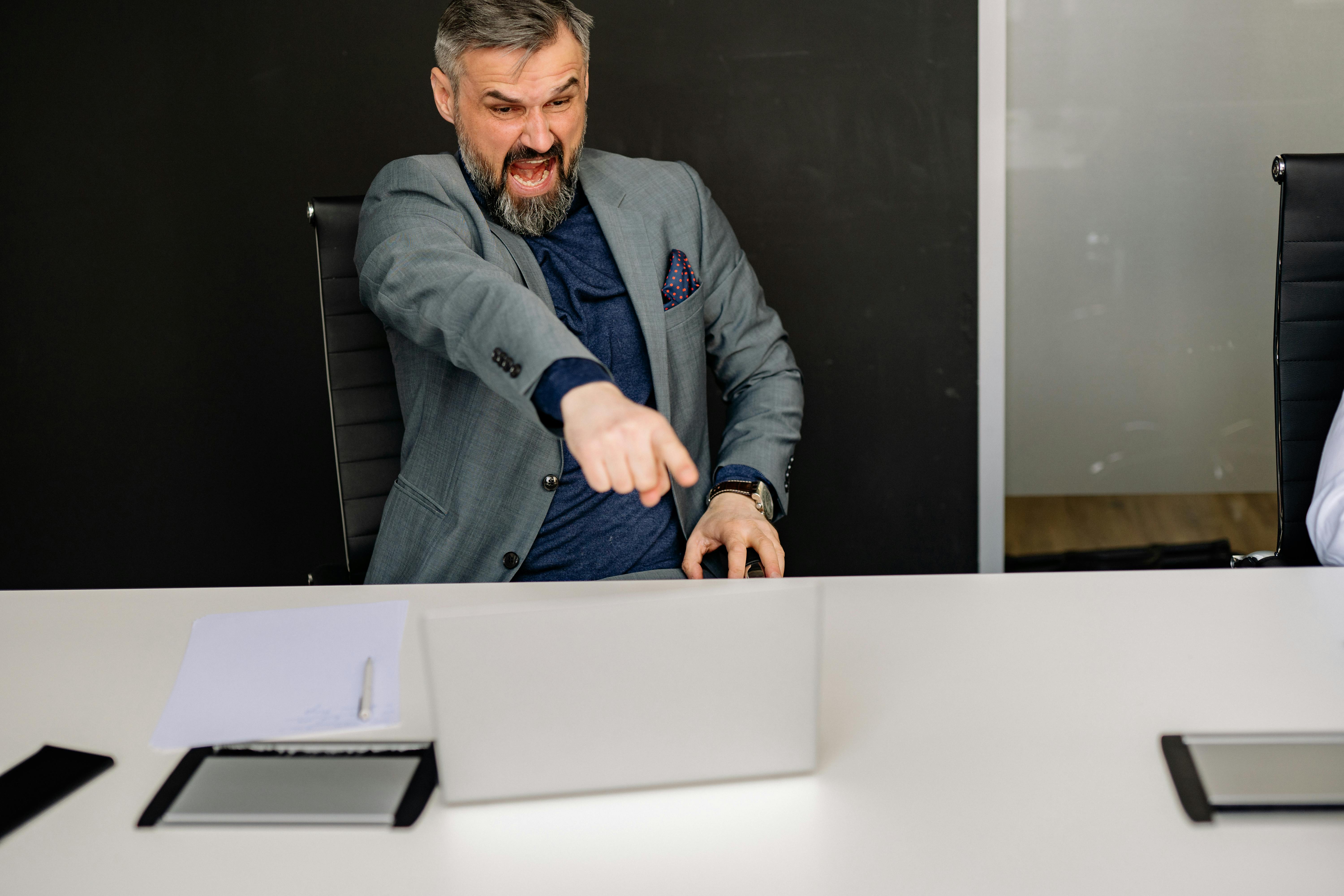 Ein wütender Geschäftsmann, der auf den Bildschirm seines Laptops zeigt | Quelle: Pexels