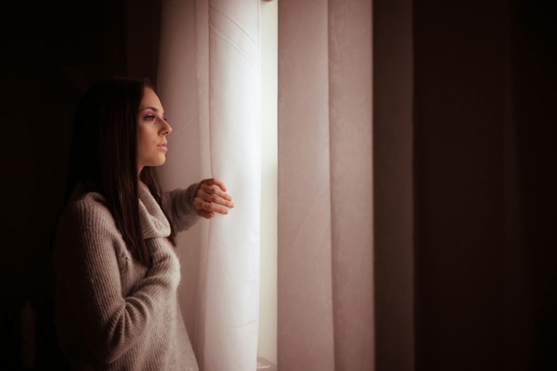 Eine Frau, die nachdenklich aus dem Fenster starrt | Quelle: Pexels