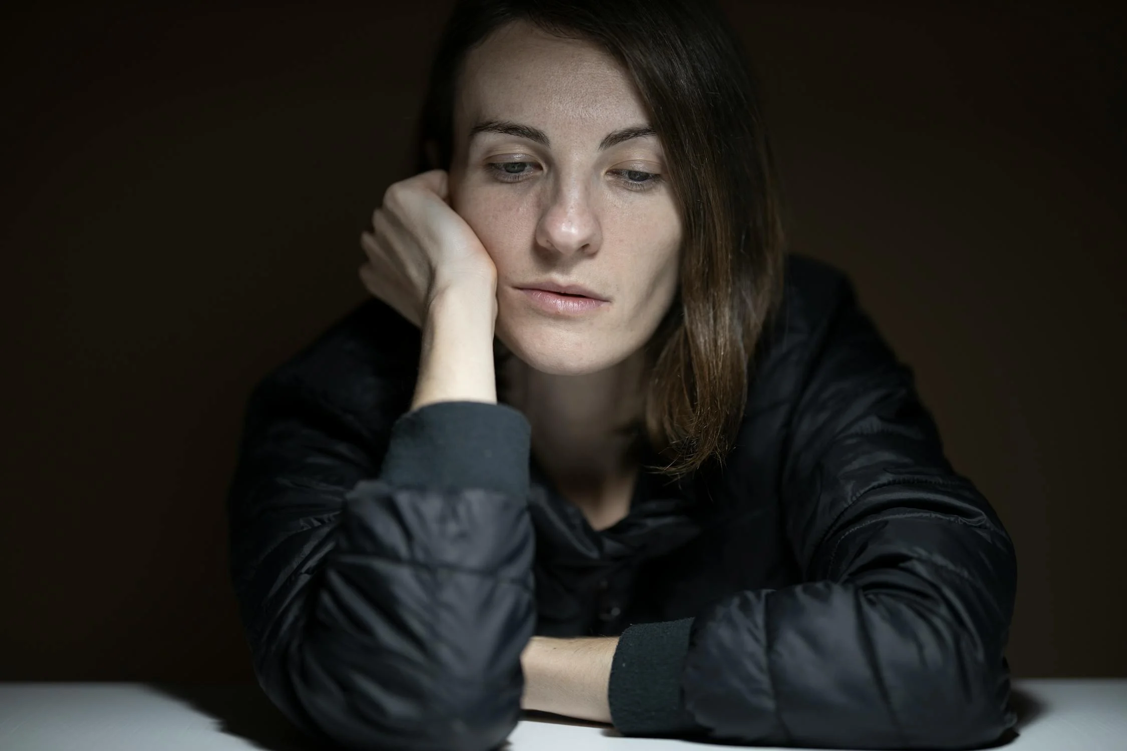 Eine traurige Frau, die an einem Tisch sitzt | Quelle: Pexels