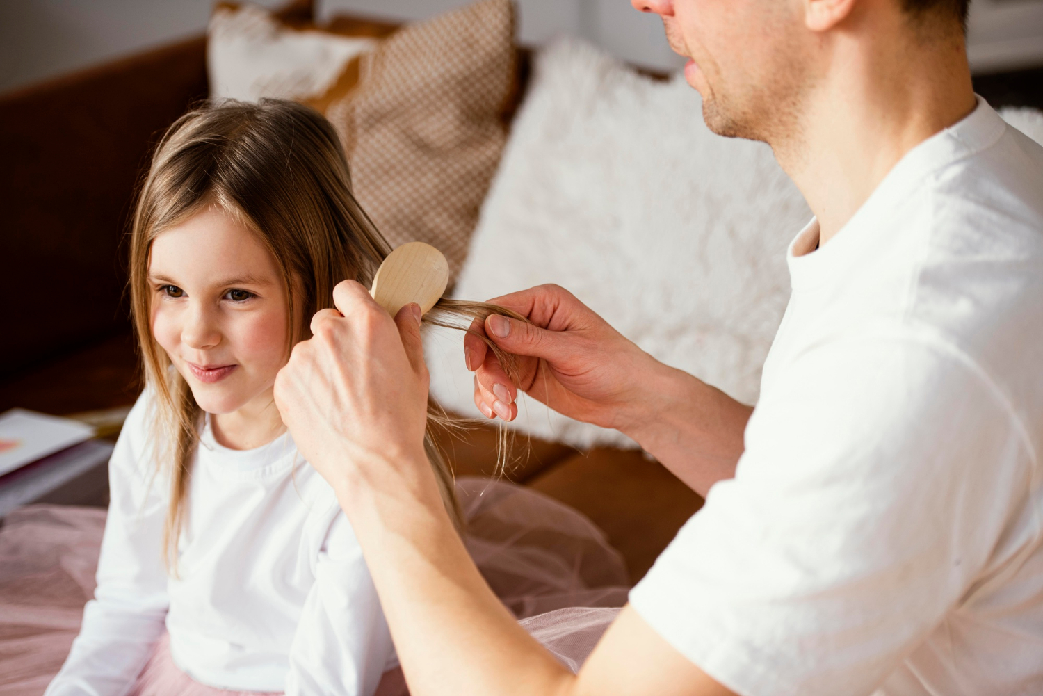 Ein Mann bürstet die Haare seiner Tochter | Quelle: Freepik